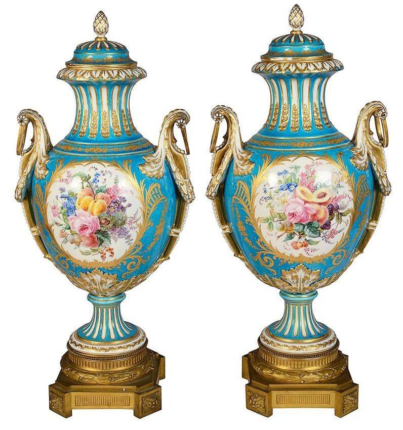 A very good quality pair of late 19th Century French Sevres style lidded vases, having a wonderful bold turquoise ground with scrolling gilded foliate decoration. A pair of raindrop handles to each. Inset hand painted panels depicting a mother and