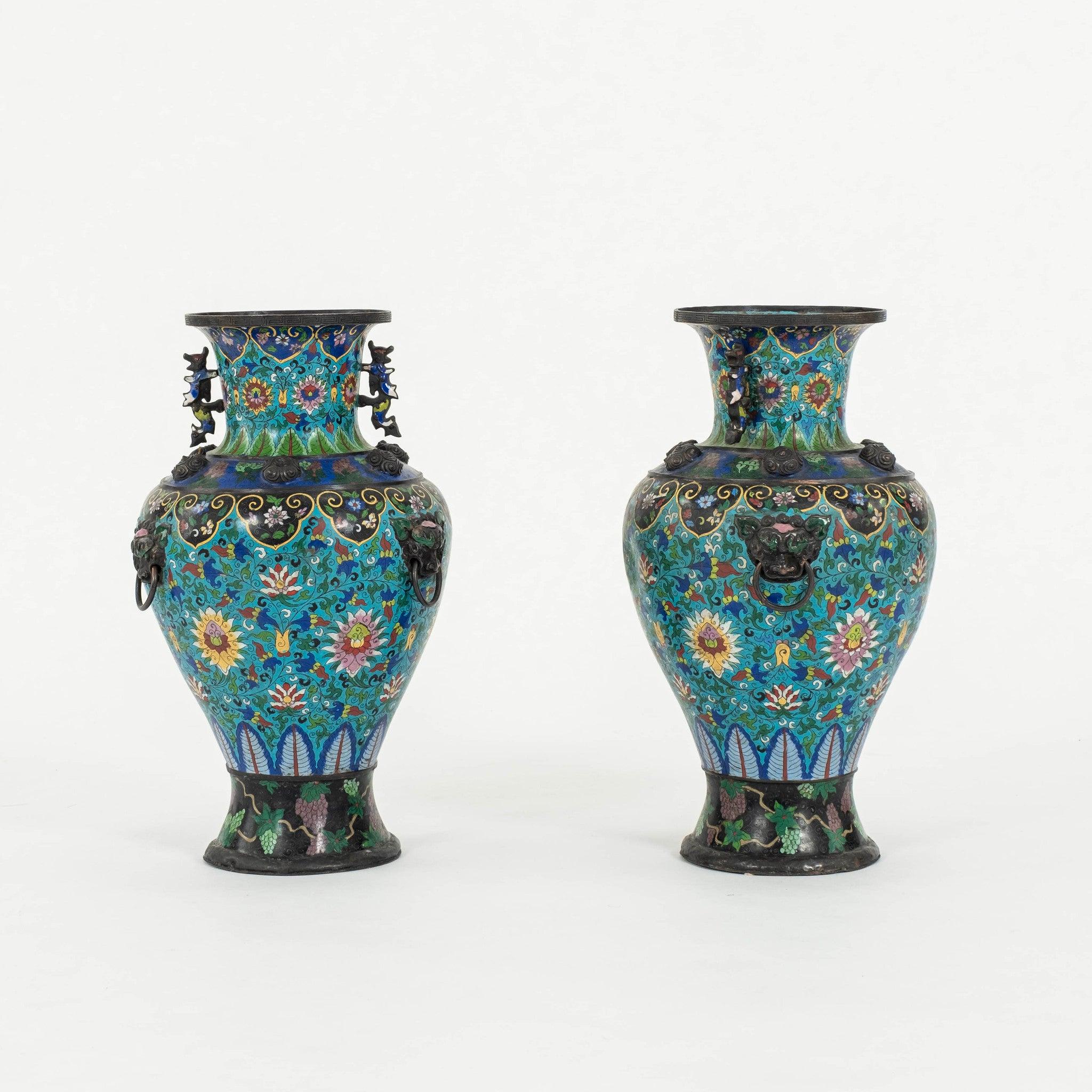 Pair of 19th Century bronze cloisonné vases. These baluster form vessels feature an enameled body with all-over polychrome foliage motifs on a turquoise ground, with two dragon handles and three guardian lion masks.