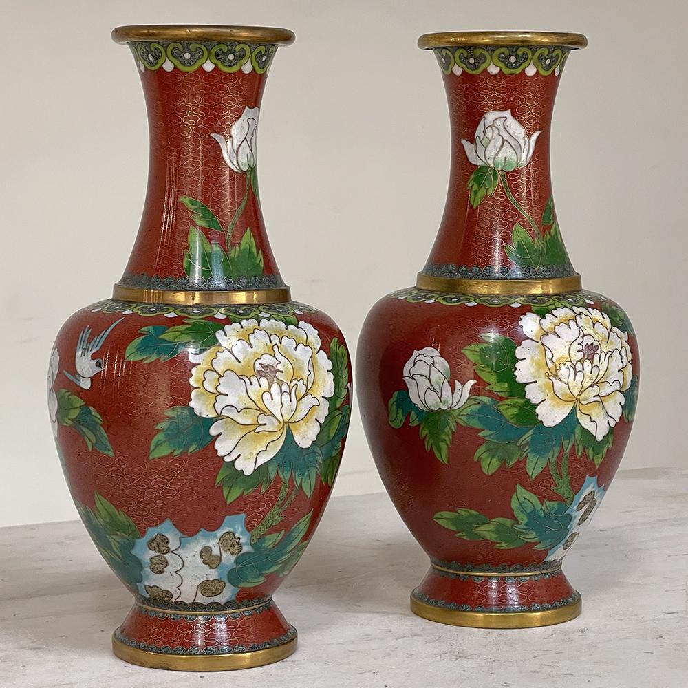 Cette paire de vases Cloissone du XIXe siècle est un exemple exceptionnel du genre. Elle conserve une riche coloration et présente un thème de design de grand format célébrant la beauté naturelle des fleurs. Décoré en rond, le fil de laiton est