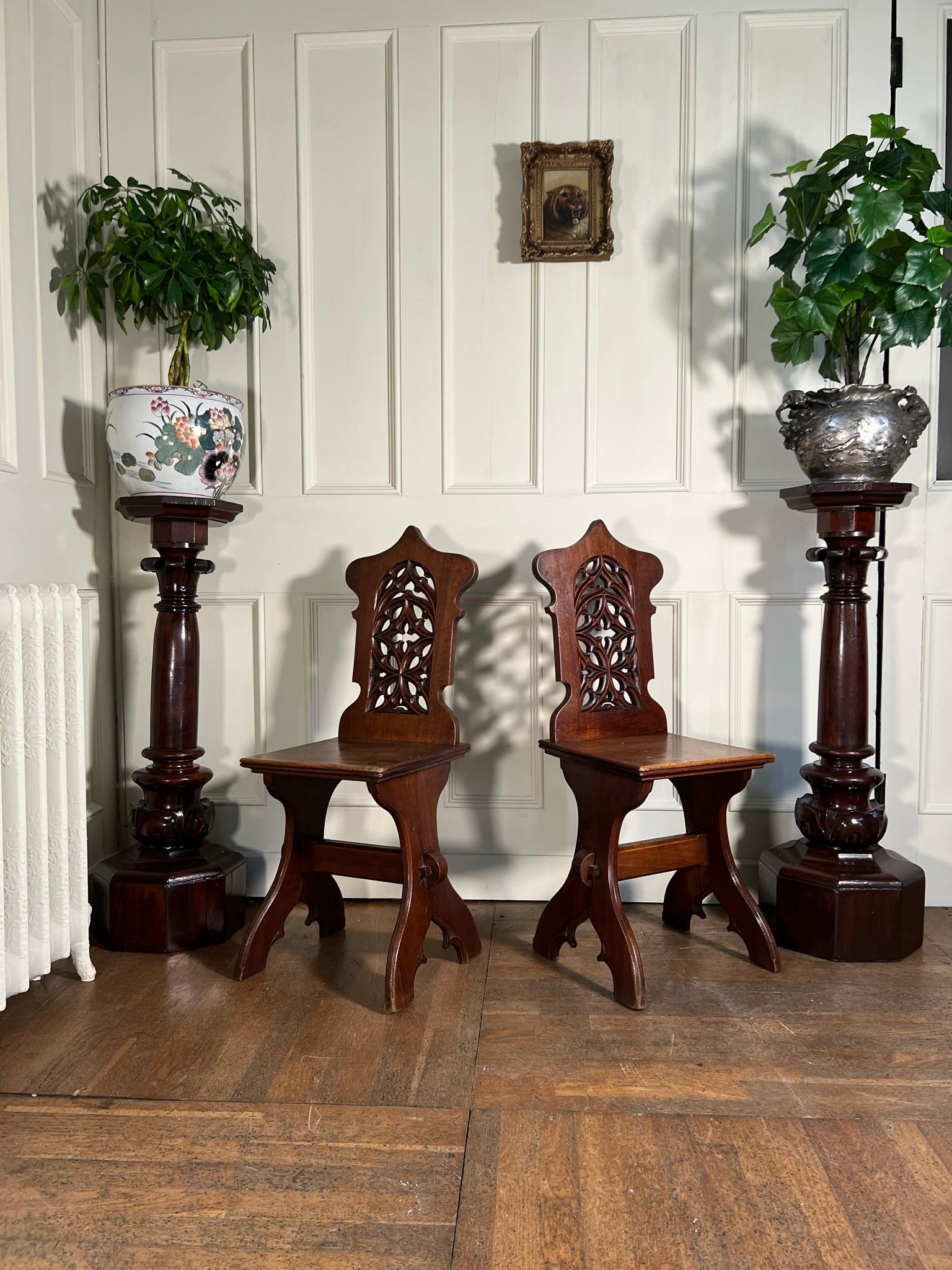 Pair 19th century continental walnut hall chairs.

Carved pierced back splat in the gothic manner.

Historic repair to one rear leg.

Measurements: 96cm H / 47cm H (seat) x 35cm W x 36cm D
(measurements are approximate and are taken at the