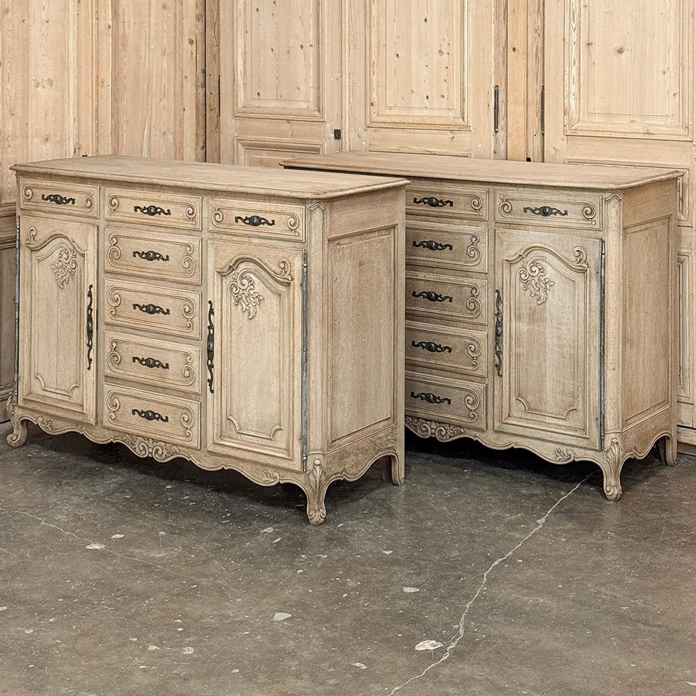 Pair 19th Century Country French Buffets in Stripped Oak are the perfect choice for adding symmetry or just a matched pair to any room!  With each featuring two spacious cabinets and no less than seven drawers, they can be used in any room.  Crafted