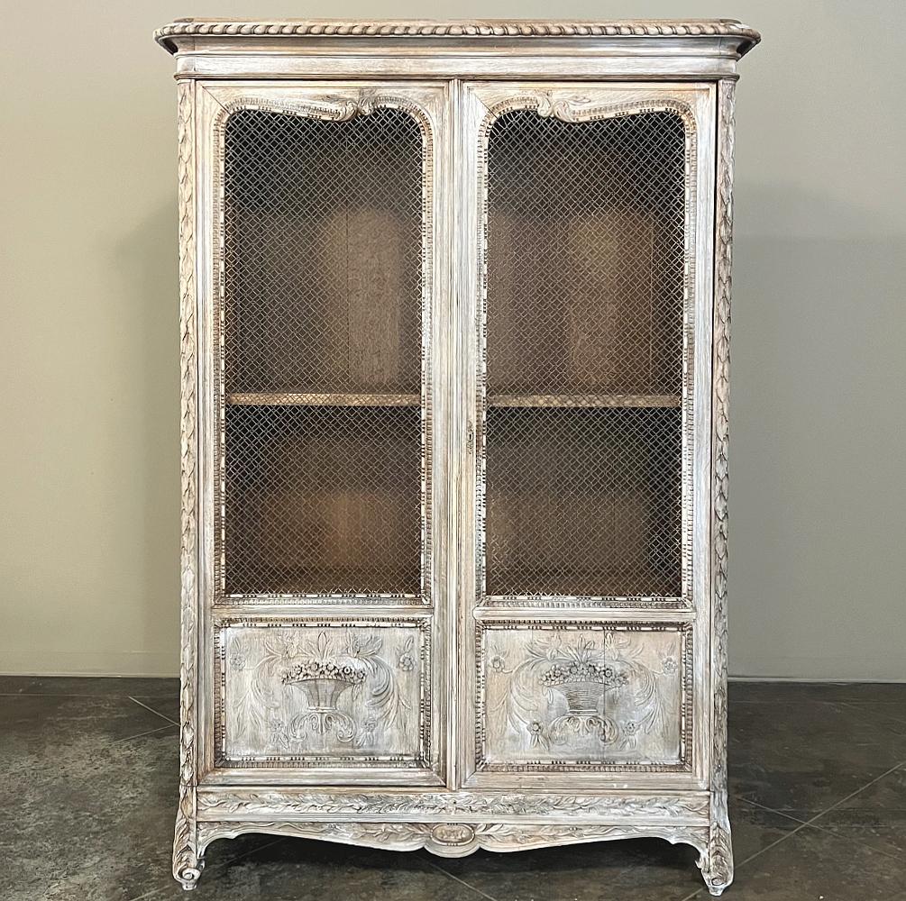 Pair 19th Century Country French Louis XVI Whitewashed Bookcases are an amazing find, and perfect for creating symmetry in your favorite room! Beautifully carved from crown to apron, each features an intriguing and unique wire mesh instead of glass,