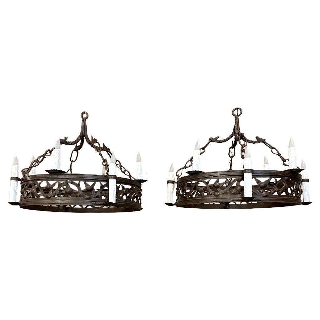 La coppia di lampadari in ferro battuto Antique French è davvero rara! Ognuno di essi è stato completamente forgiato a mano con ferro arroventato sull'incudine del fabbro. Per prima cosa sono stati realizzati i doppi cerchi, poi saldati insieme con