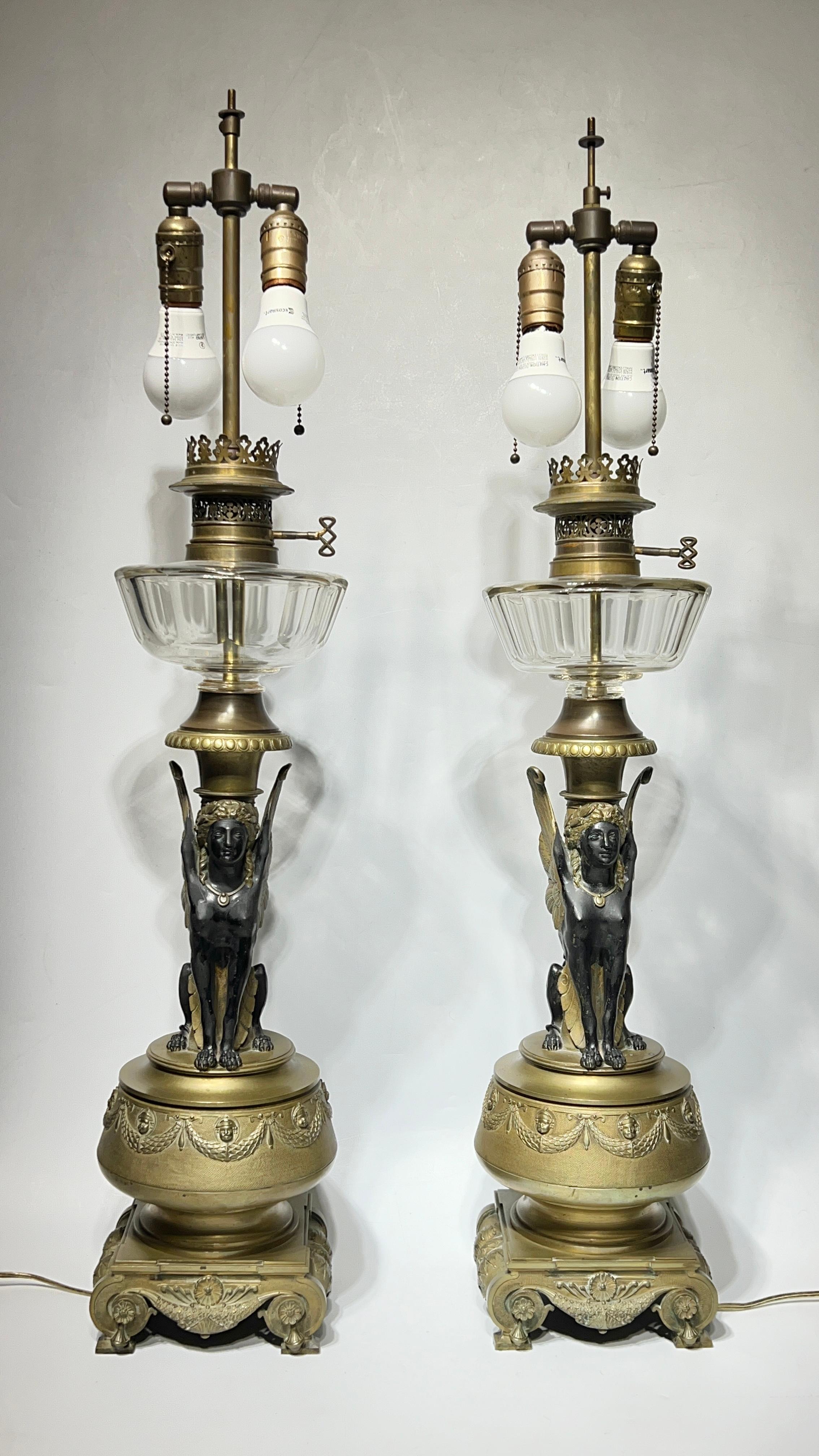 Paire de lampes à huile anciennes (19e siècle) de style empire français en bronze doré et en verre de la période néo-égyptienne, électrifiées au début du 20e siècle.  Chacun a une hauteur impressionnante de 37 pouces.