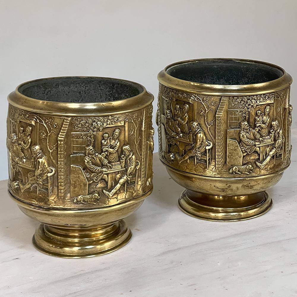 Pair 19th century embossed brass jardinieres with tin liners will make a great addition to your decor! Each features boldly embossed scenes on the entire exterior depicting a couple of gentlemen playing a board game while being watched by a woman
