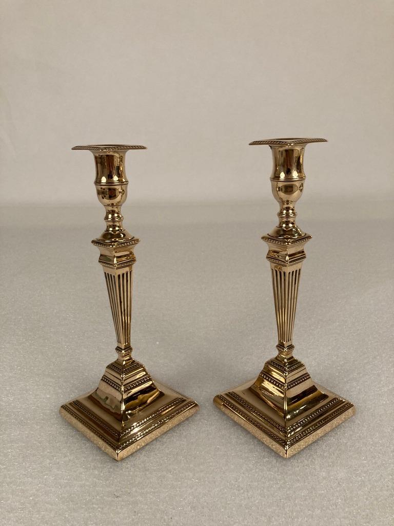 Pair of neoclassical style early 19th century English candlesticks with a push mechanism to remove the spent candle easily. Handsome and quite elegant.