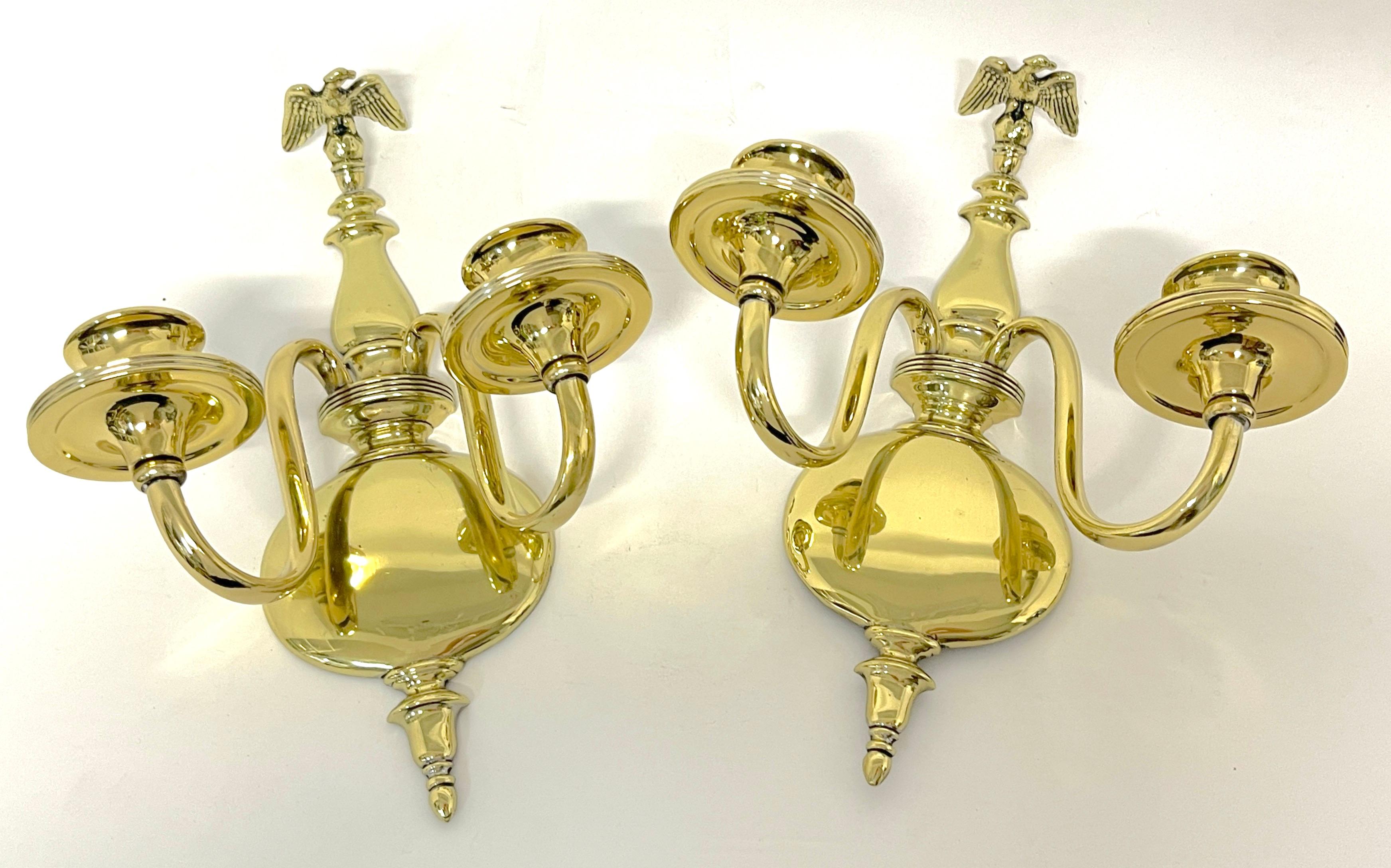 Pair 19th century English Regency brass eagle two-light candle wall sconces 
England, Regency Revival Mid-19th Century or older

Each one well cast with a perched eagle atop, supported by an undulating urn and ball backrest, with two graceful