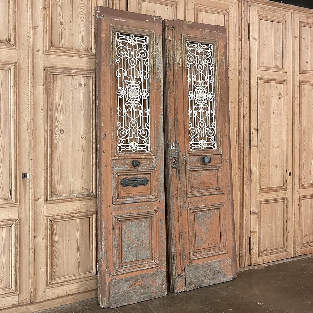 Pair 19th century Exterior French doors with wrought iron will make the perfect choice to make an entryway unique, or to just hang on the wall as faux passageways, or just for decorative appeal! handcrafted from thick planks of oak, they were