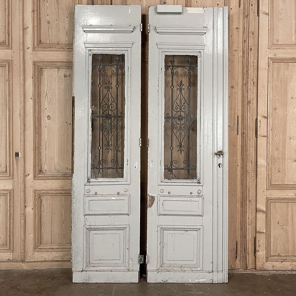 Pair 19th century Exterior French doors with wrought iron will make the perfect choice to make an entryway unique, or to just hang on the wall as faux passageways, or just for decorative appeal! Hand-crafted from thick planks of oak, they were