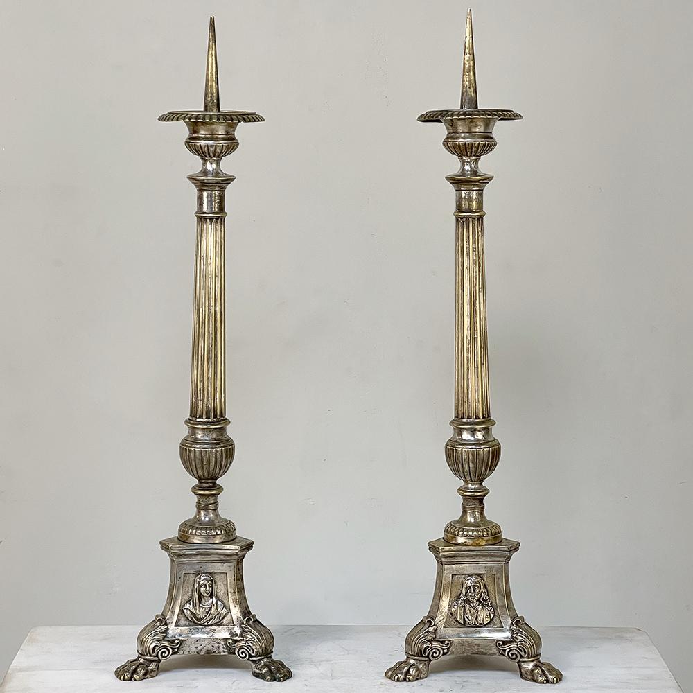 Pair 19th century French cast brass Altar candlesticks were crafted with images of the Holy Family in glorious full relief on the three facades of the intricate bases. Jesus, Mary and Joseph appear in classic poses with each image adorning one of