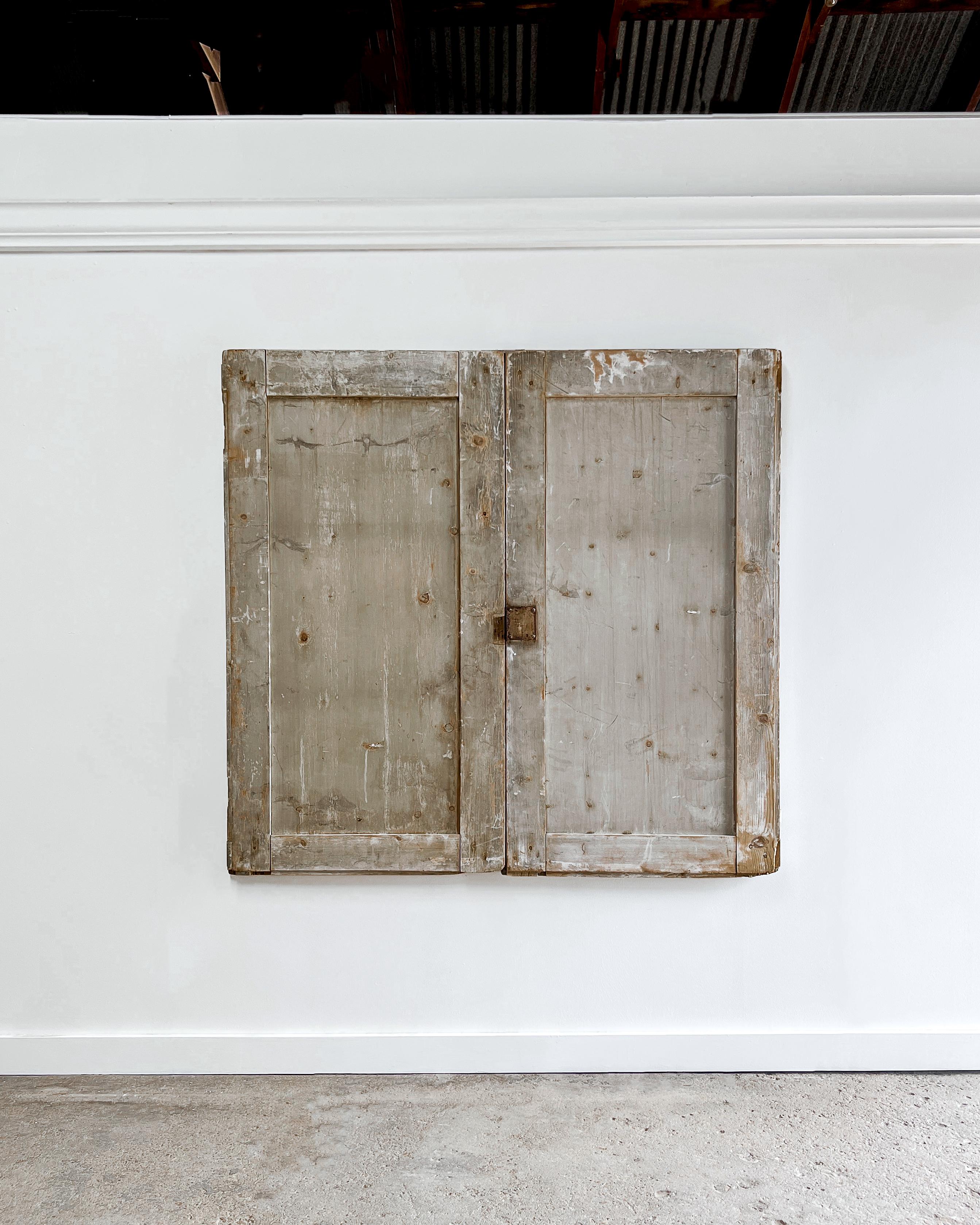 A pair of reclaimed flat panel cupboard doors with beveled trim details. Unpretentious, yet full of charm thanks to the time-worn patinated finish, these doors would enhance the look of an otherwise unassuming built-in cabinet in a modern home by