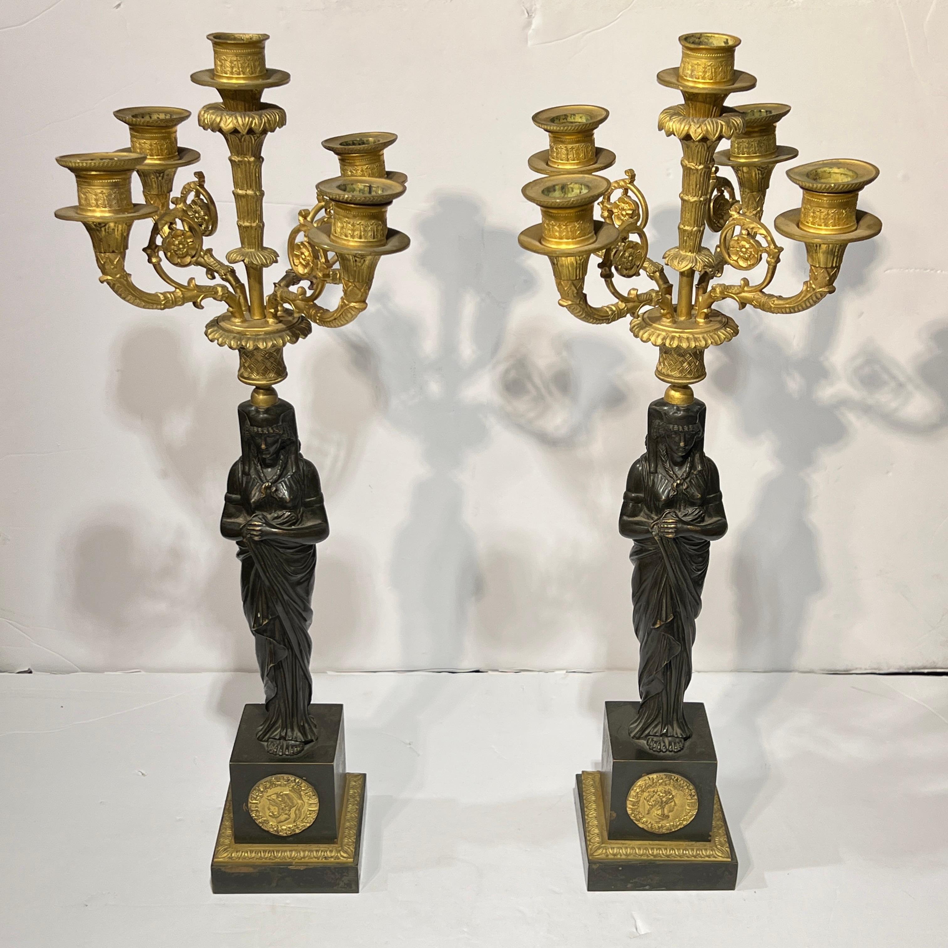 Coppia di candelabri antichi finemente lavorati (XIX secolo) in bronzo patinato e dorato in stile Impero che misurano 19 3/4 pollici di altezza e 7 pollici di larghezza e profondità, con figure patinate di dee in abiti egiziani, quattro bracci di