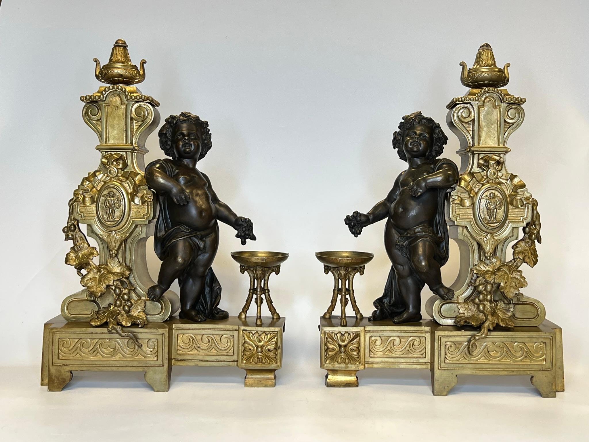 Pair of 19th century French ormolu bronze andirons in the Louis XVI style with patinated bronze figures of standing putti (cherubs).