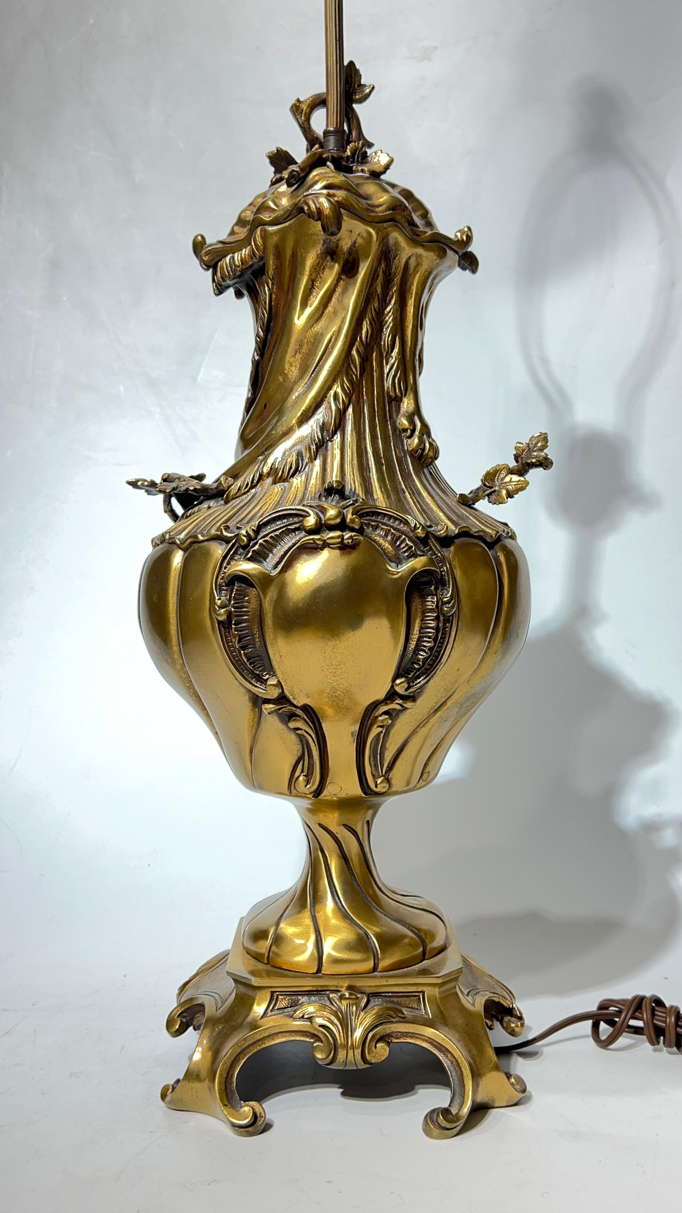 Paire de lampes anciennes en bronze de style Louis XV, 36,5 x 8 x 8 pouces, y compris les harpes de la lampe, de forme cassolette en forme d'urne drapée de peaux de lion, avec des poignées en vigne et des bases carrées à pieds.  20 lbs. chacun.
La