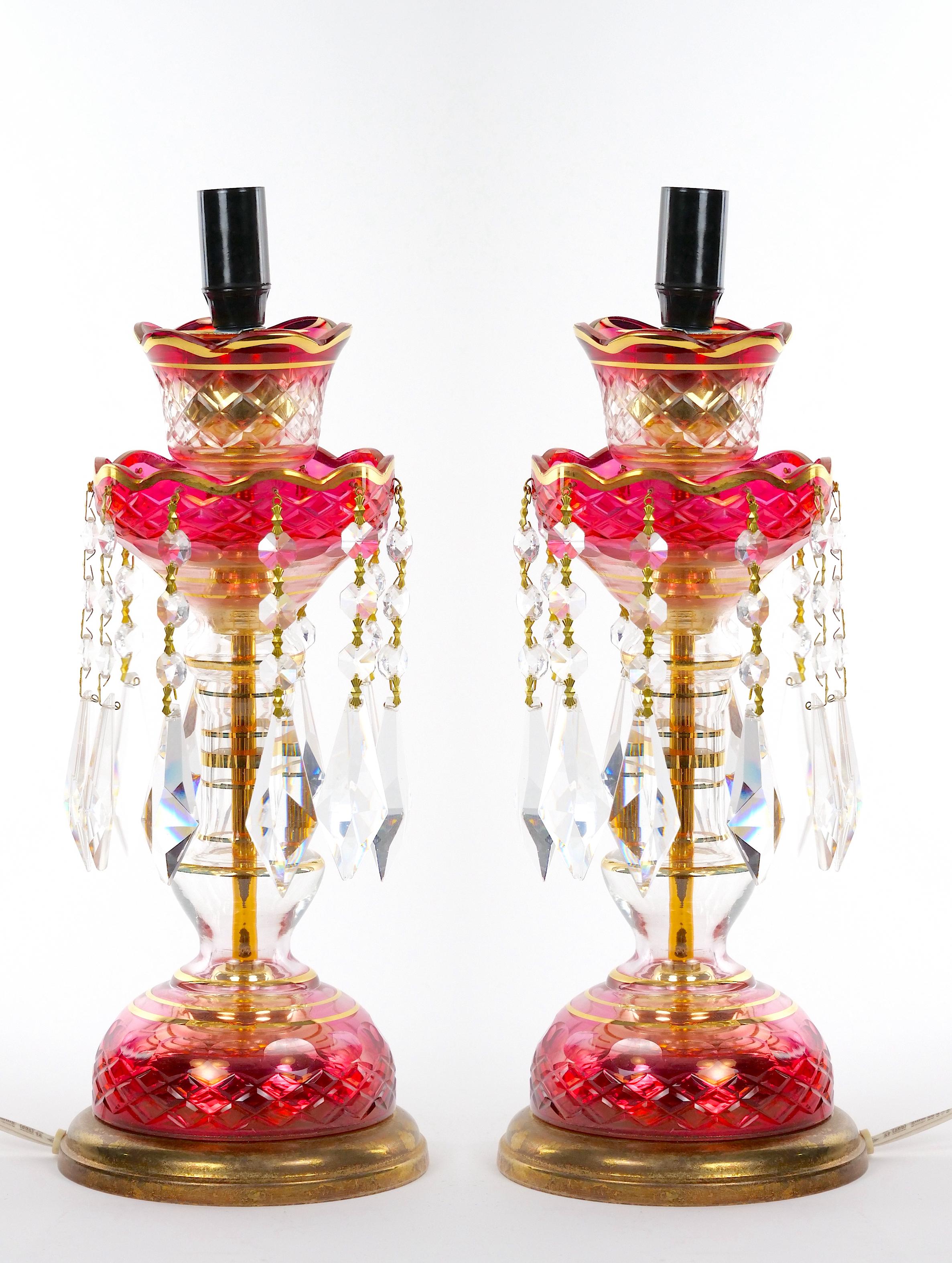 Beautiful pair of antique 19th century glass lusters (candlesticks) modified for use as table lamps with their original cranberry red-to-clear cut glass hurricane-form shades with elongated starburst and cross-hatch motifs, gilt metal standards with