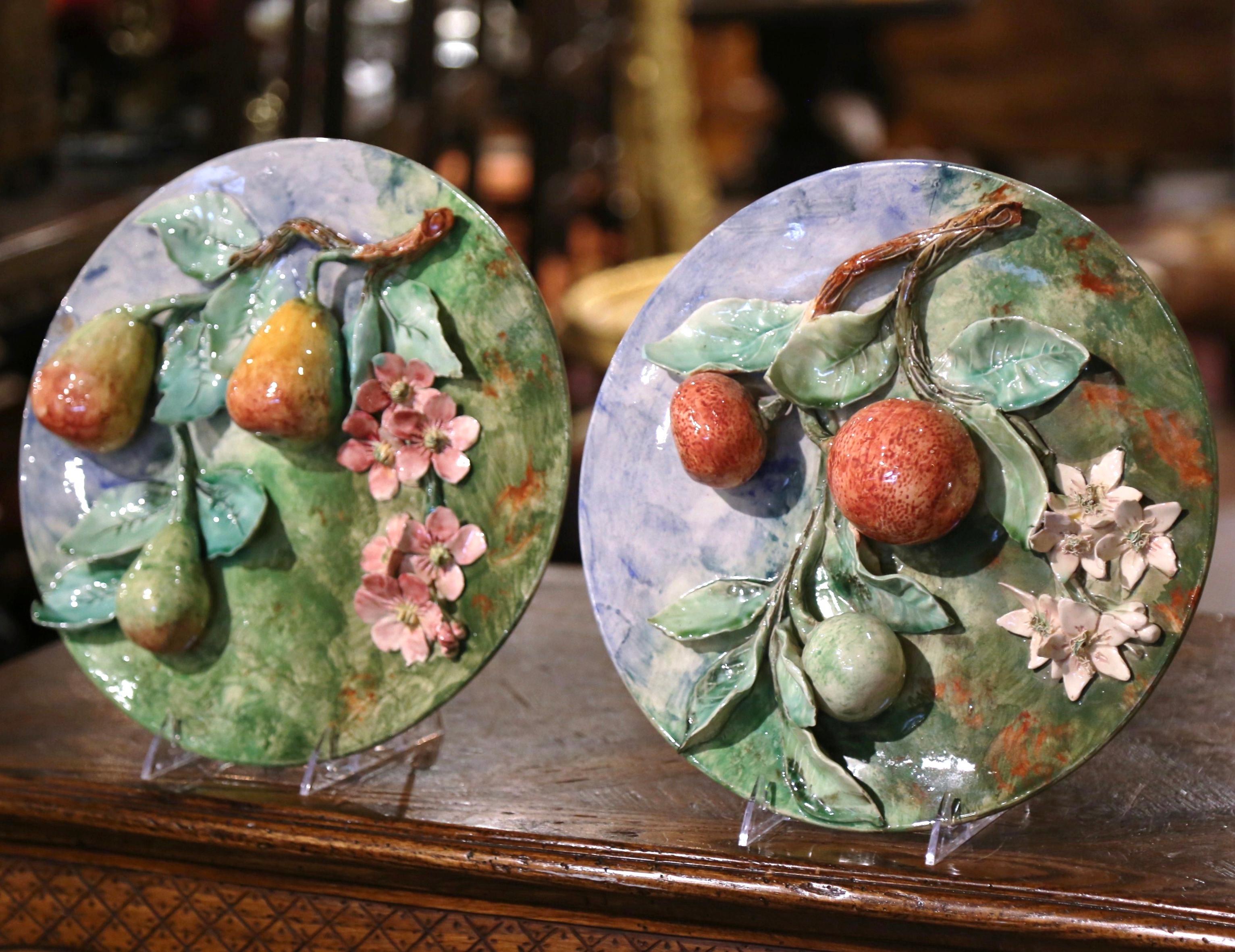 Add some color to your kitchen wall or dining room shelf with this beautiful pair of antique Majolica plates. Crafted in France, circa 1880, each plate features sculptural fruit motif in high relief which includes apples and pears hanging from tree