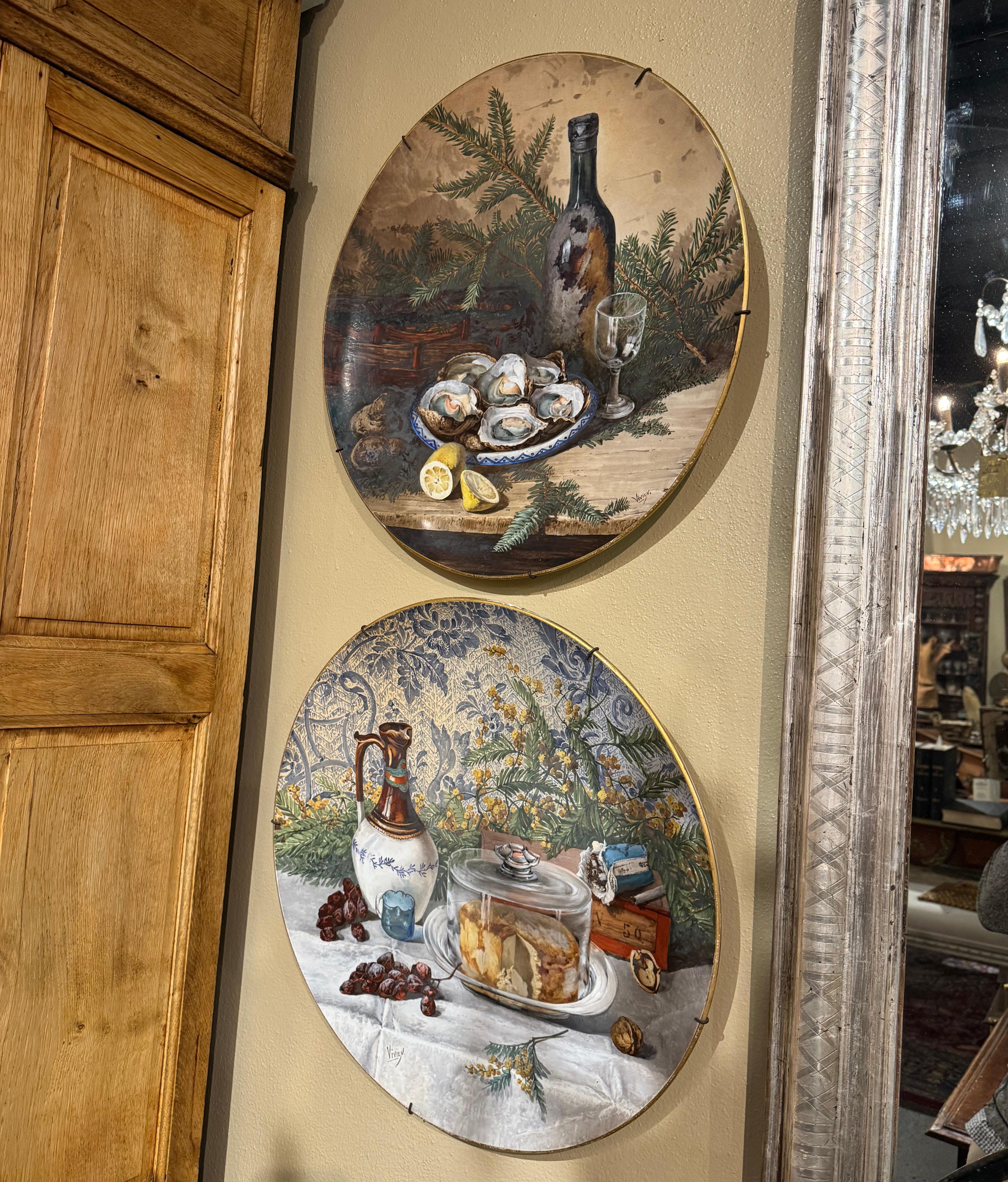Decorate a kitchen wall, a breakfast room or a restaurant with this large and colorful pair of antique platters. Crafted in France circa 1870 and round in shape, both hand painted porcelain plates feature a still life composition depicting all the