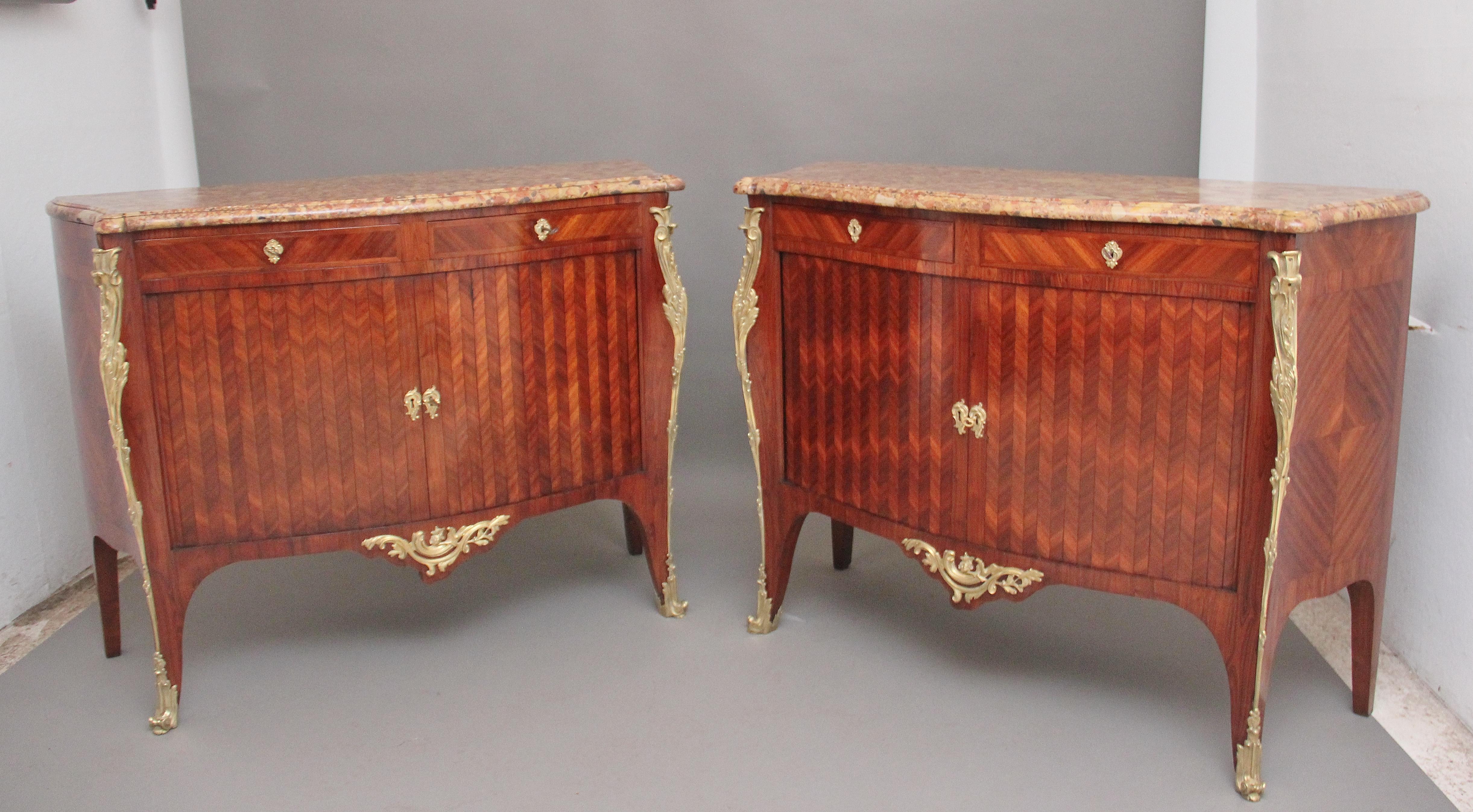A pair of 19th century French Kingwood and marble top commodes of exceptional quality, having the original highly decorative shaped marble tops with a moulded edge, two oak lined drawers below and a two tambour door opening to reveal a large
