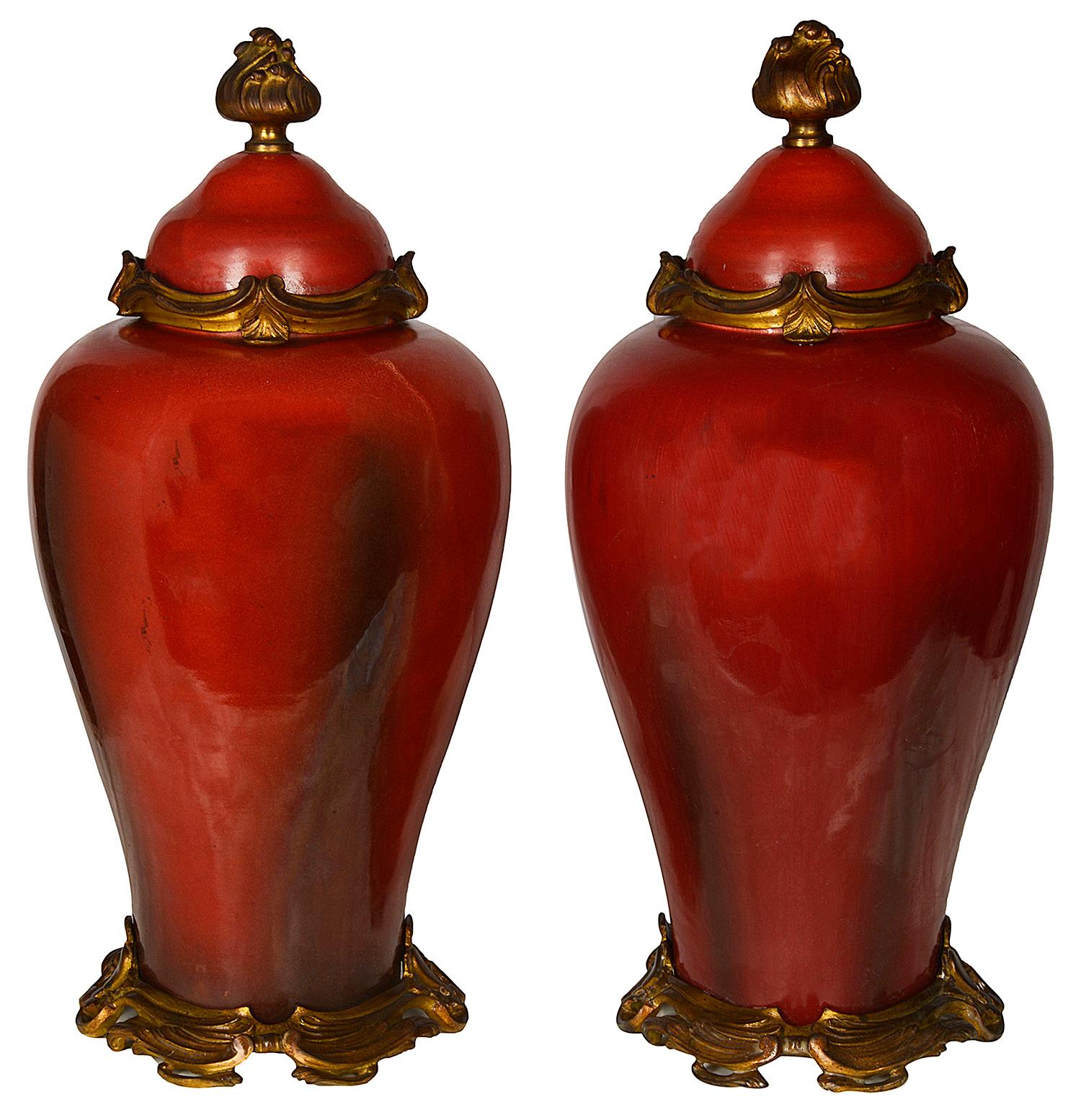 A striking pair of 19th century French gilded ormolu mounted lidded porcelain vases in the Chinese Sang du bouf style. Each mounted with wonderful Rococo style finials, collars and bases.
We can have these converted to lamps if needed within the