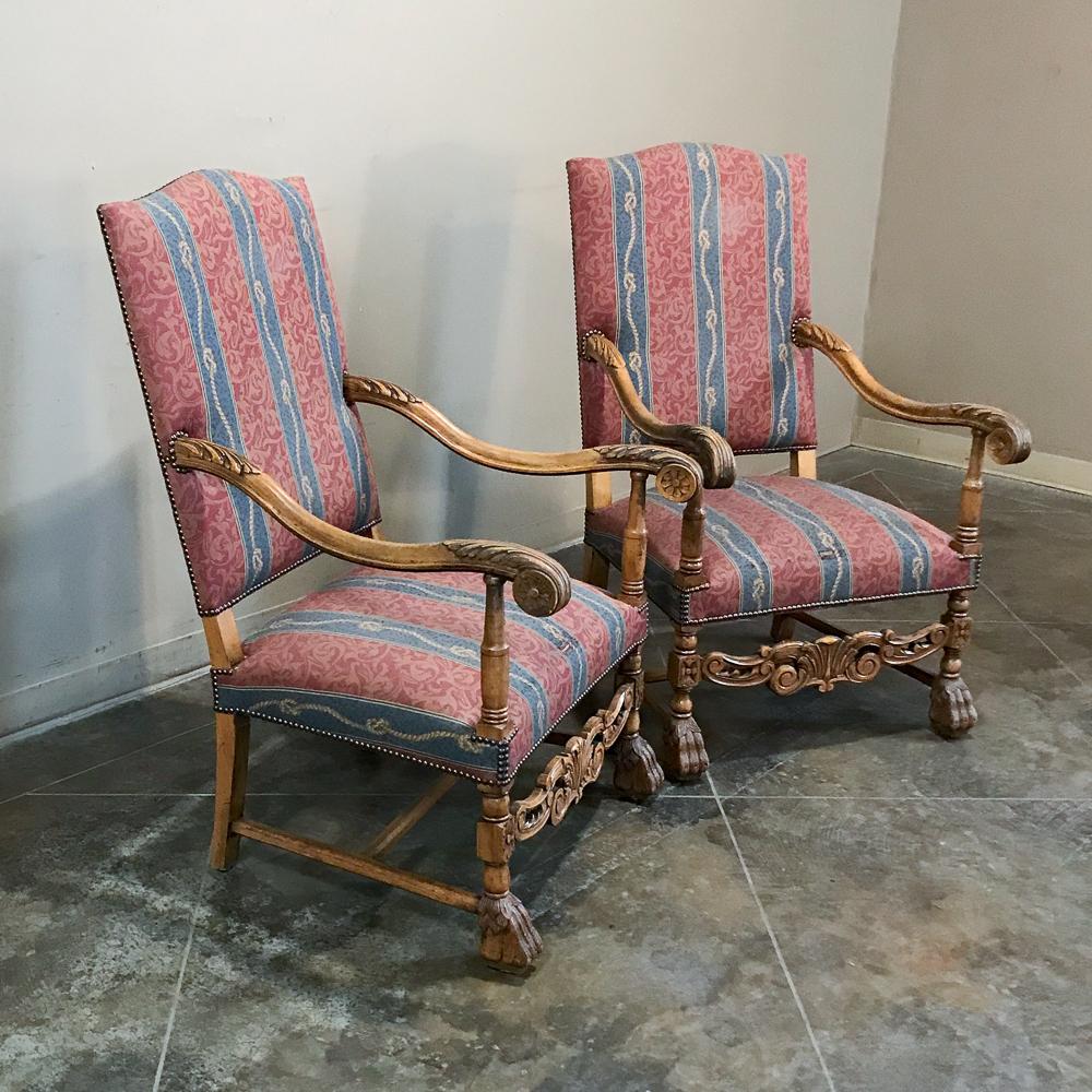 Pair 19th century French Louis XIII armchairs are of a grand size for their time, making them ideal for 21st century homes! Beautifully carved with graceful armrests and lions' paw feet, each features a carved transverse apron across the front for a