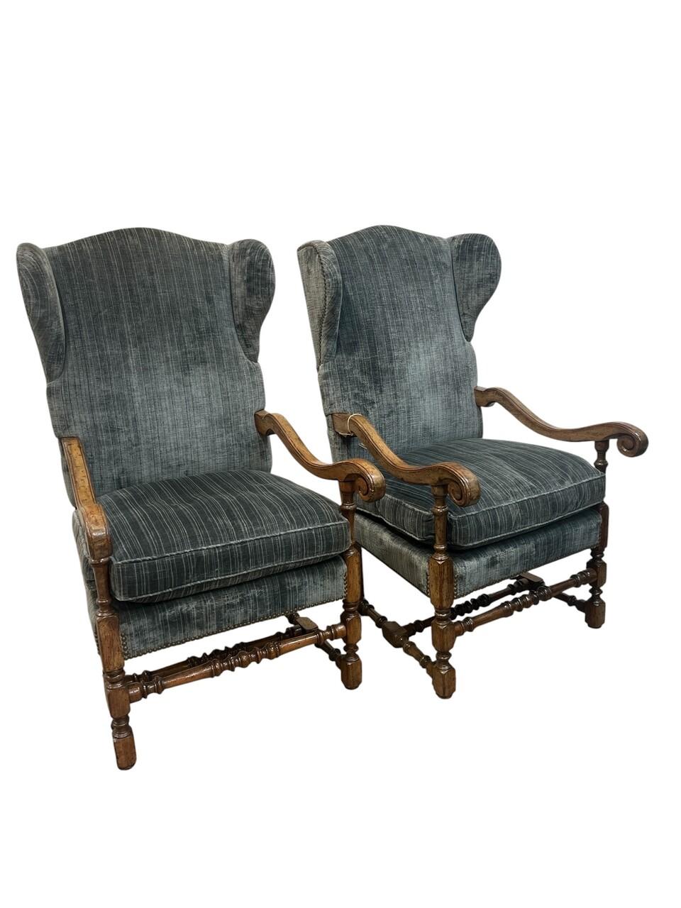 Pareja de sillones Luis XIV franceses del siglo XIX, de nogal tallado, con brazos en forma de volutas y tapicería de terciopelo rematada con cabezas de clavos.