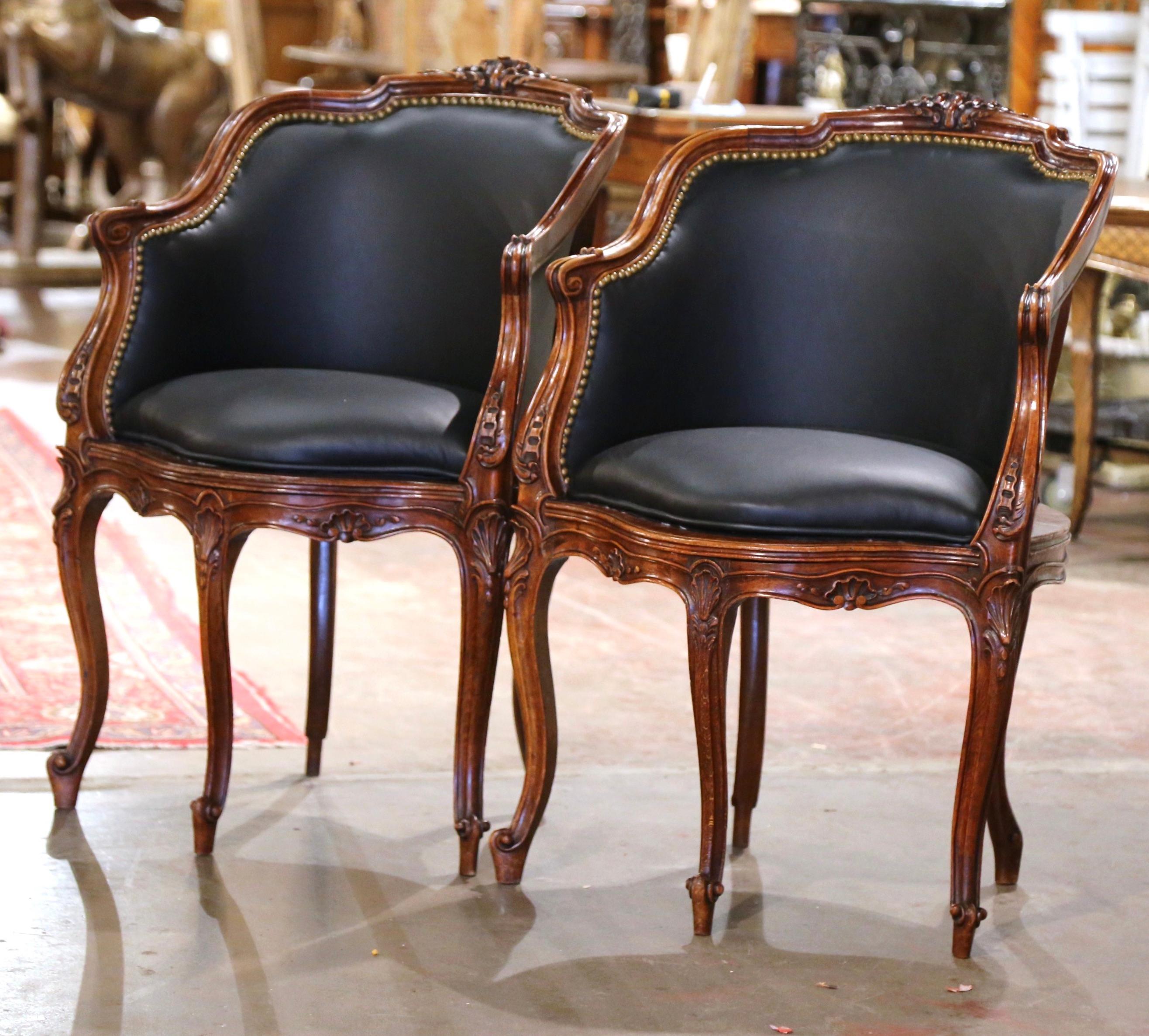 Decorate a study or office with this elegant pair of antique desk armchairs. Crafted in Provence, France, circa 1880, each corner chair has an arched back decorated with a shell motif at the pediment. The traditional corner chair stands on five