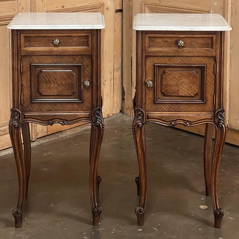 This lovely pair of 19th century French Louis XV walnut nightstands is topped with Beveled Carrara Marble, and speaks to the hand-crafted quality of furnishings from France during the period. Finely figured walnut veneering appears throughout the