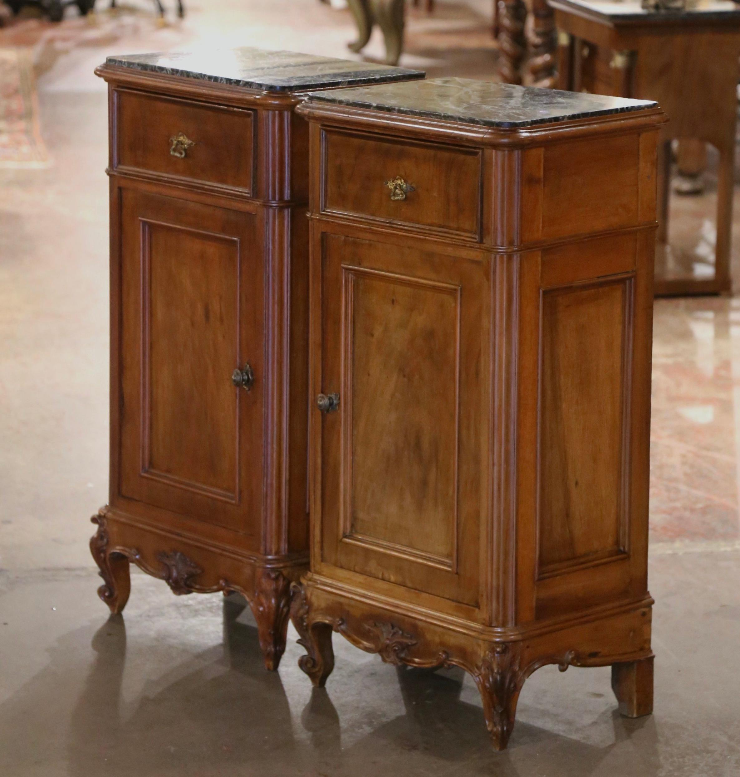 Add surface space in your bedroom with this elegant pair of antique nightstands. Crafted in France circa 1880, each cabinet built of walnut, stands on escargot feet over a scalloped apron decorated with a shell motif; each traditional piece with