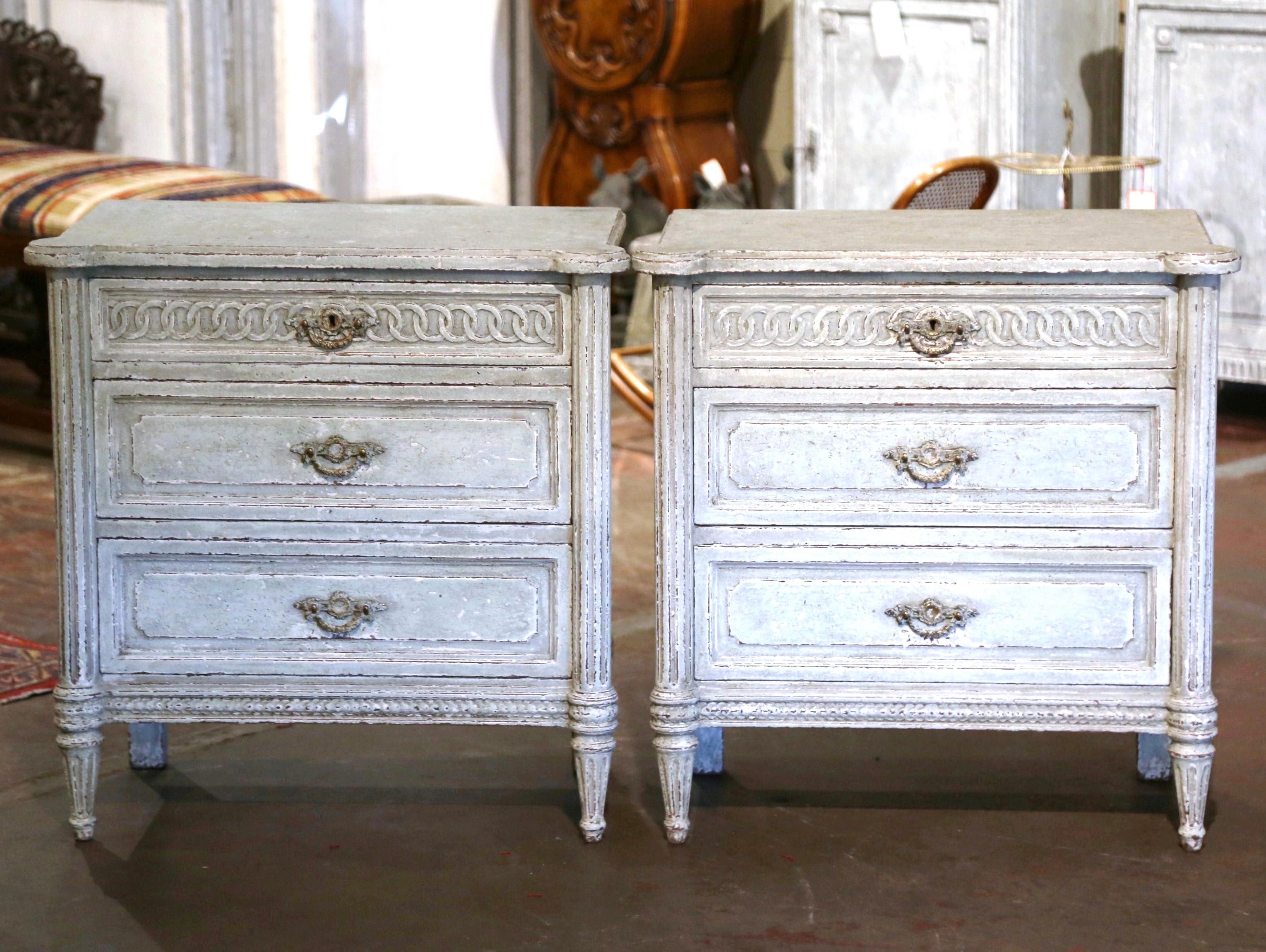 Complete your bedroom with this elegant pair of antique hand painted bedside cabinets. Crafted in France, circa 1880, each commode stands on tapered and fluted legs over a straight apron decorated with geometric motif. Each chest features three