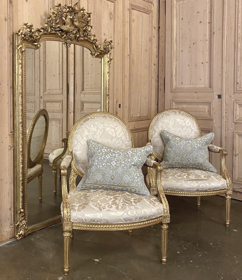 Pair of 19th century French Louis XVI Gilded armchairs ~ fauteuils are a rare find because of their size! Typical chairs from the era are smaller, so these were obviously custom ordered for what is now a more 21st century physique. Intricately