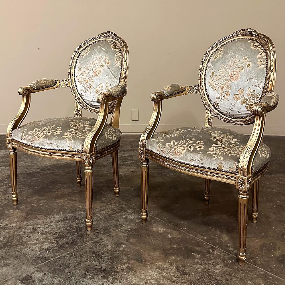 Pair 19th century French Louis XVI Gilded Armchairs ~ Fauteuils are a truly timeless representation of the neoclassic form inspired by the ancient Greeks and Romans! Carved from hand-select hardwood, each features an oval, contoured seat back and