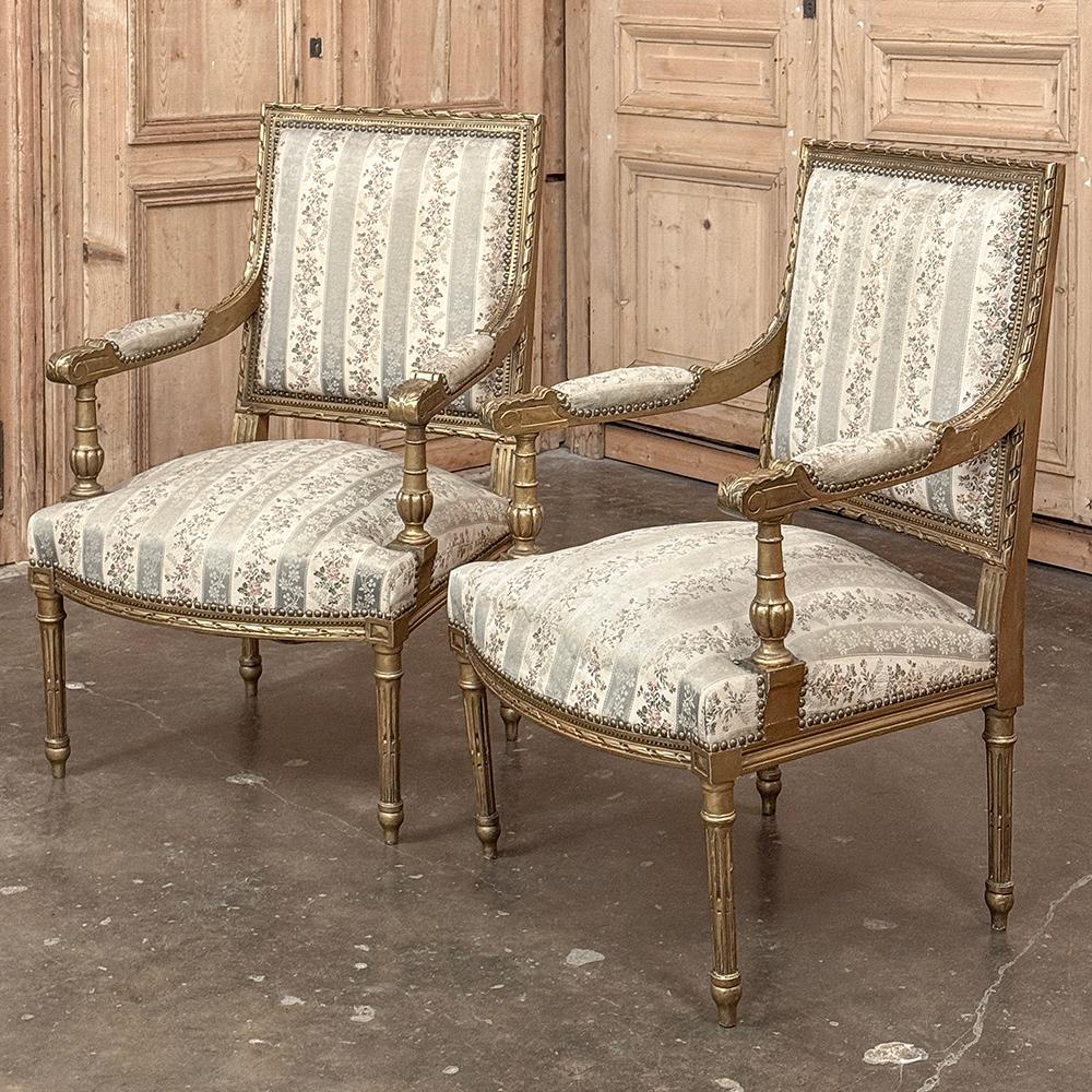 ¡Pareja de Sillones Franceses Luis XVI Dorados del Siglo XIX ~ Los Fauteuils añadirán elegancia clásica atemporal a cualquier ambiente!  El diseño presenta un aspecto abierto y aireado gracias a los reposabrazos suspendidos y las patas cónicas y