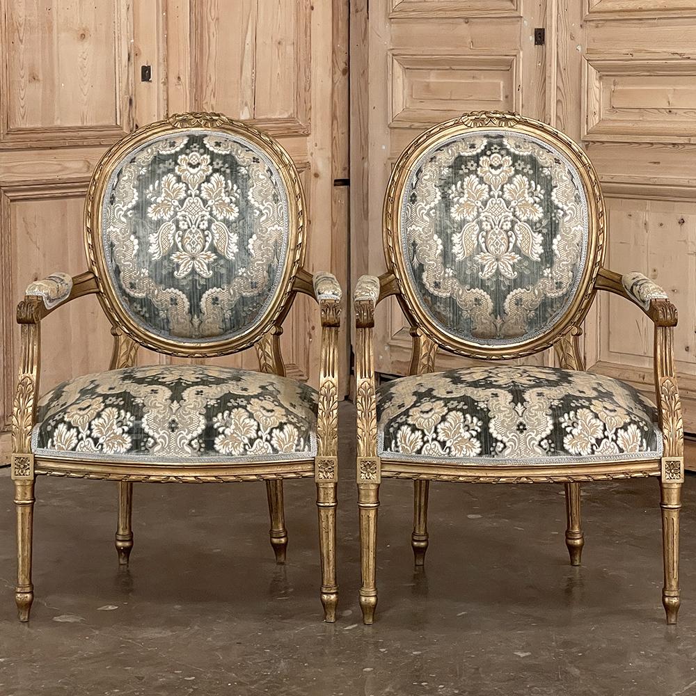 Pair 19th Century French Louis XVI Giltwood Armchairs ~ Fauteuils represent the epitome of the genre, with elegant contoured oval seat backs and generous seats surrounded by hand-carved giltwood for sublime opulence!  The molded trim is primarily of