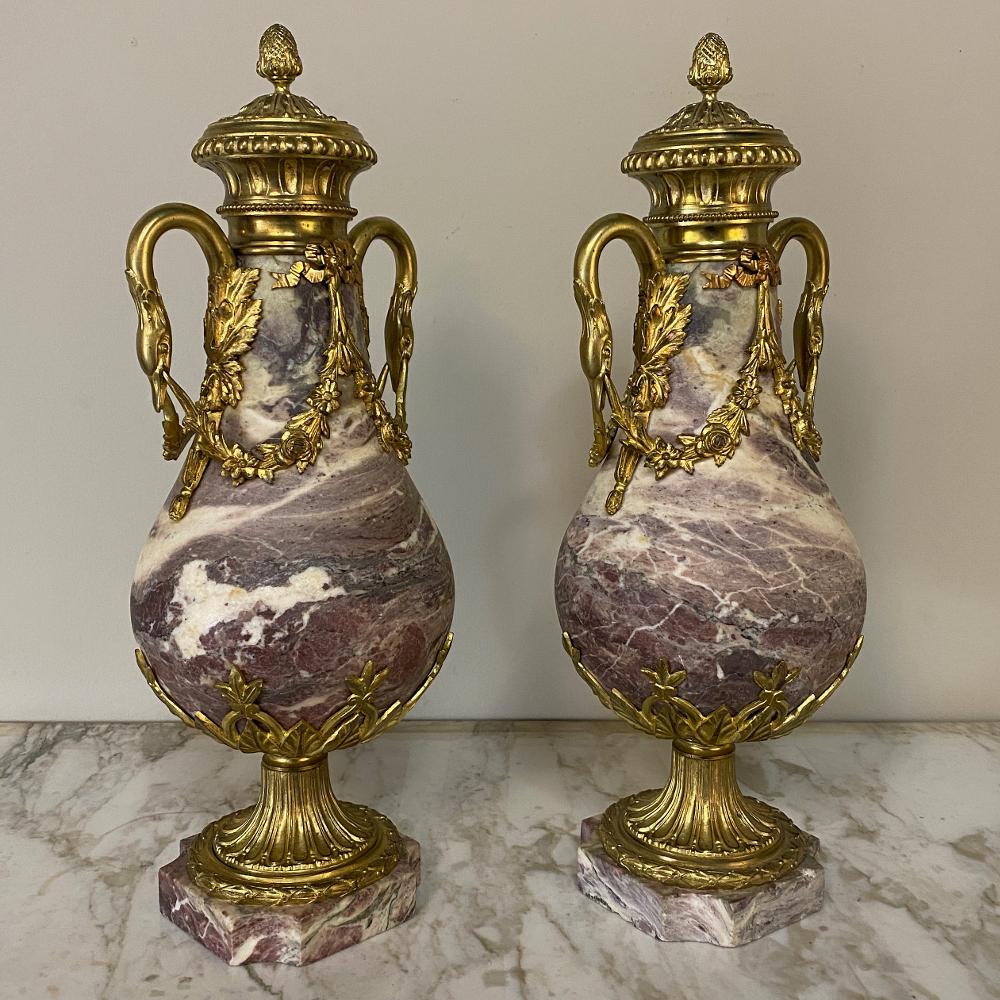 Pair of 19th century French Louis XVI marble and bronze Cassolettes represent the epitome of affluence! handcrafted from exquisitely veined marble and festooned with bronze mounts from the top to the base, such a pair was a sign of wealth and