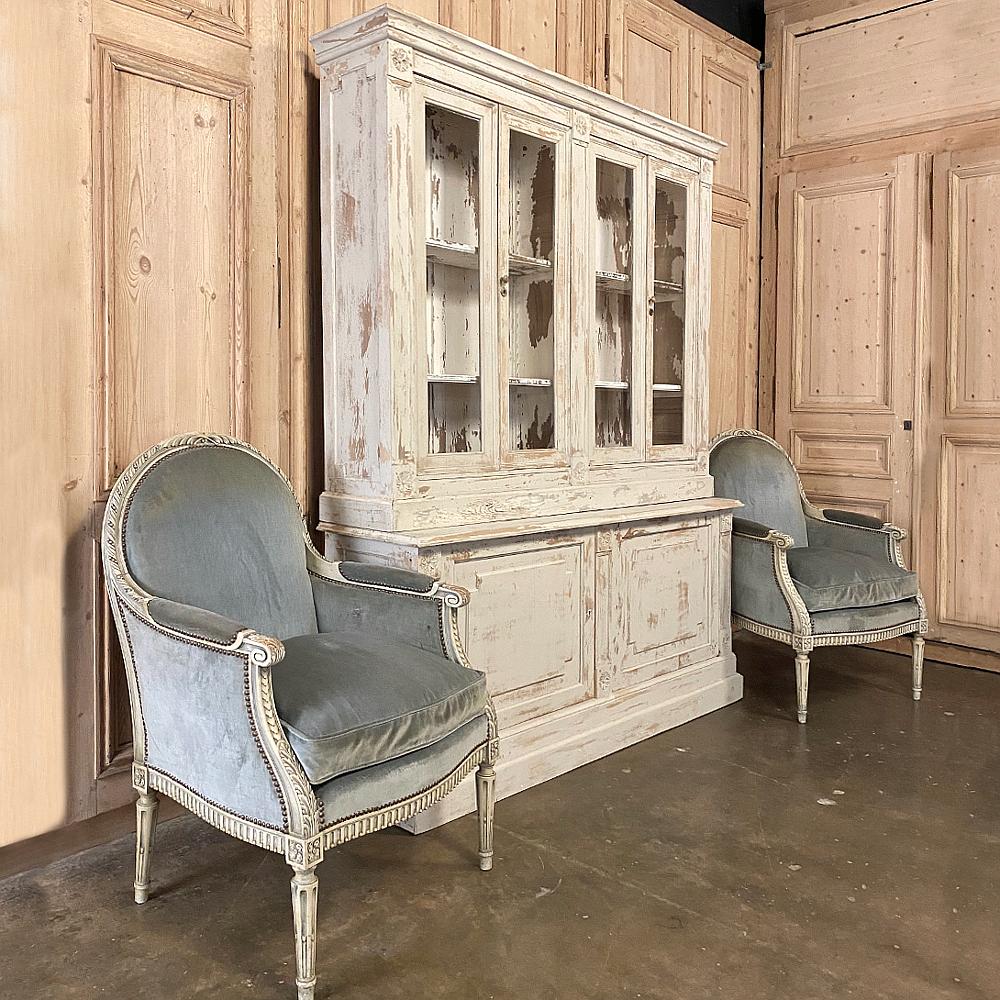 Pair of 19th century French Louis XVI painted bergères ~ armchairs feature a Classic design that provides incredible comfort, timeless styling, yet a minimal visual weight thanks to the sleek architecture. Hand carved framework includes reeded and