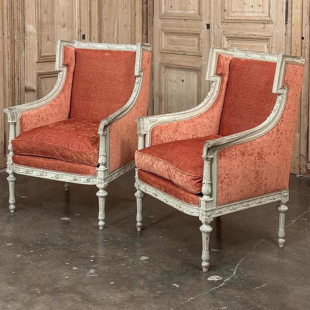 Paire de Bergeres peintes Louis XVI du 19ème siècle ~ Les fauteuils ajouteront à la fois confort et élégance à n'importe quelle pièce !  Fabriqué à la main par des artisans talentueux, chaque cadre est entièrement sculpté depuis les couronnes du