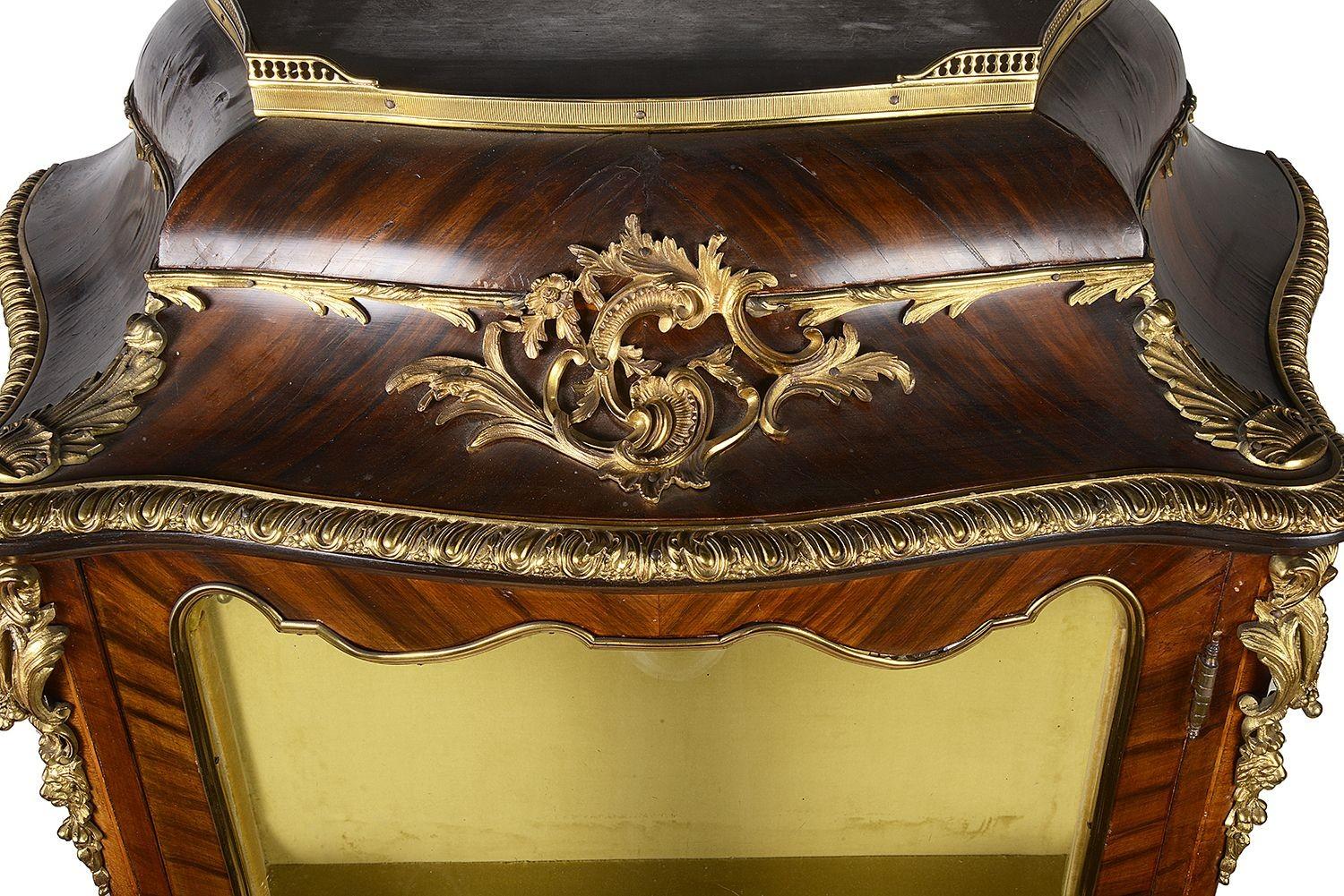 A pair of very good quality pair of late 19th century French Louis XVI style bombe vitrines, each with scrolling foliate and rams head gilded ormolu mounts, wonderful marquetry + parquetry floral inlaid panels, single doors opening to reveal a