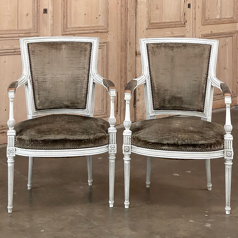 Pair Antique French Louis XVI Painted Armchairs represent a style transition into the Directoire look, where a more tailored design created a cleaner appearance. The squared off, contoured seat backs combine with generous seats for comfort,
