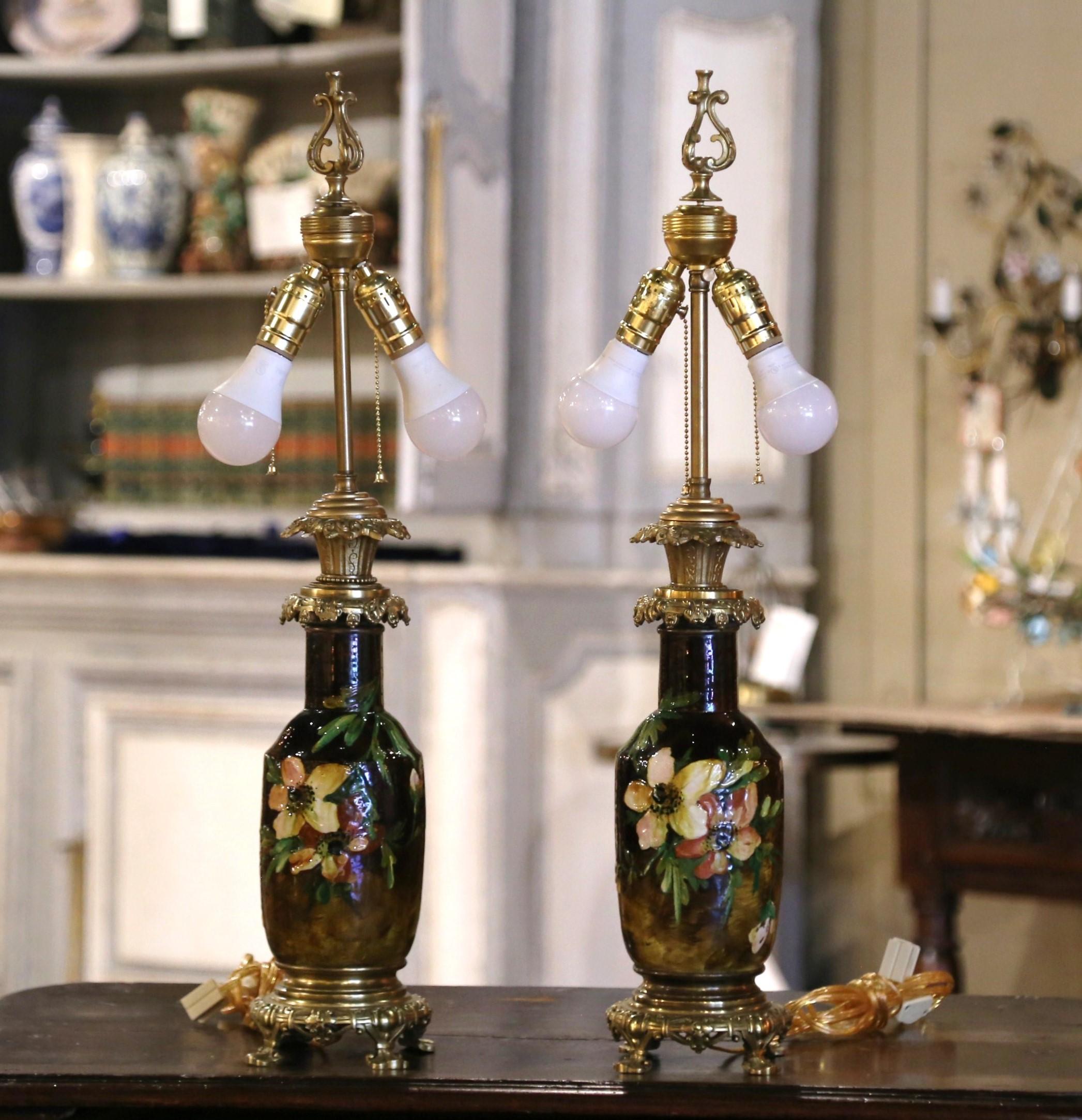 Décorez les tables de chevet ou une console avec cette élégante paire de lampes de table en faïence ancienne. Fabriqué à Montigny sur Loing, en France, vers 1860, chaque vase orné repose sur une base en bronze complexe terminée par des pieds en