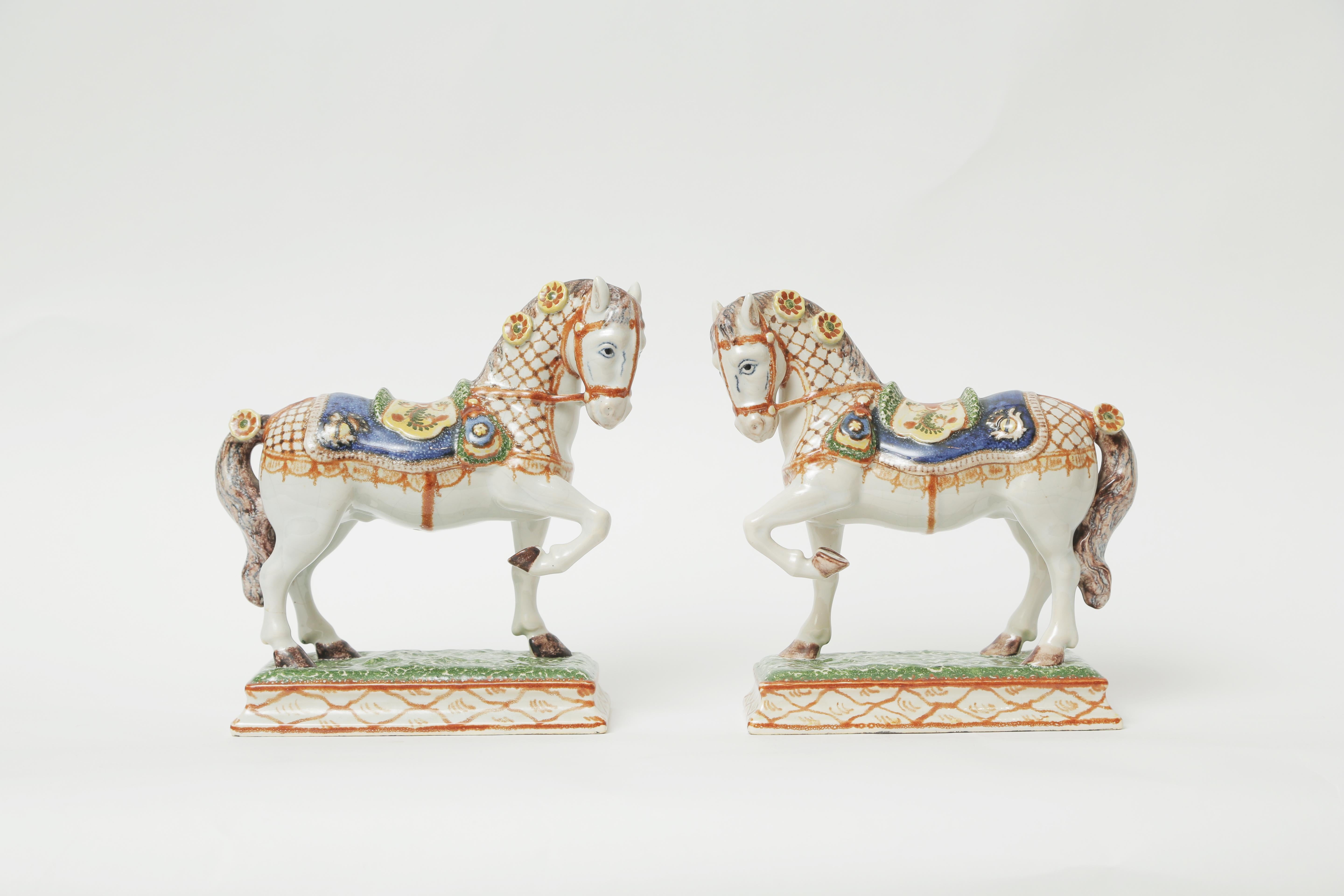 A charming, well sculpted and painted pair of horse figurines on a nice raised pedestal base. Wonderful attention to detail and great vivid coloring. Please note the dimensions as they are very impressive in size. In very nice antique condition and