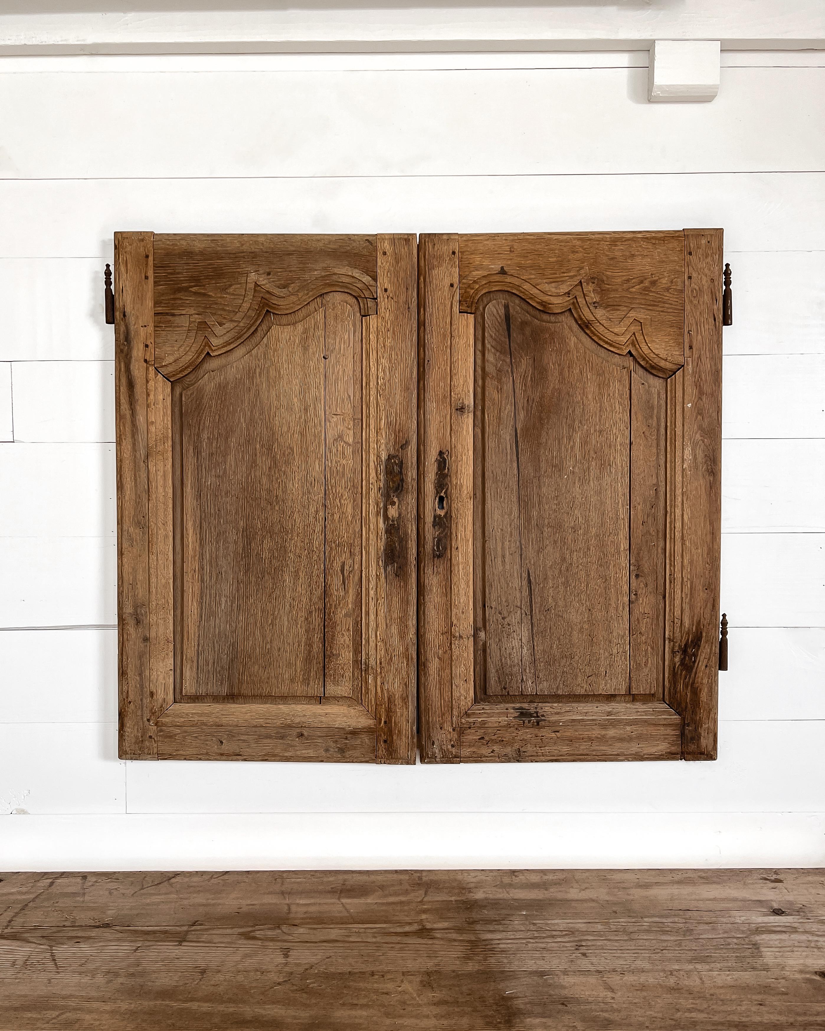 A pair of reclaimed provincial cupboard doors with hand-carved details. Enclose a built-in cabinet with these charming doors to feel as if you’ve been transported to the French countryside.

Salvaged in France, 19th century.

Crafted from oak having