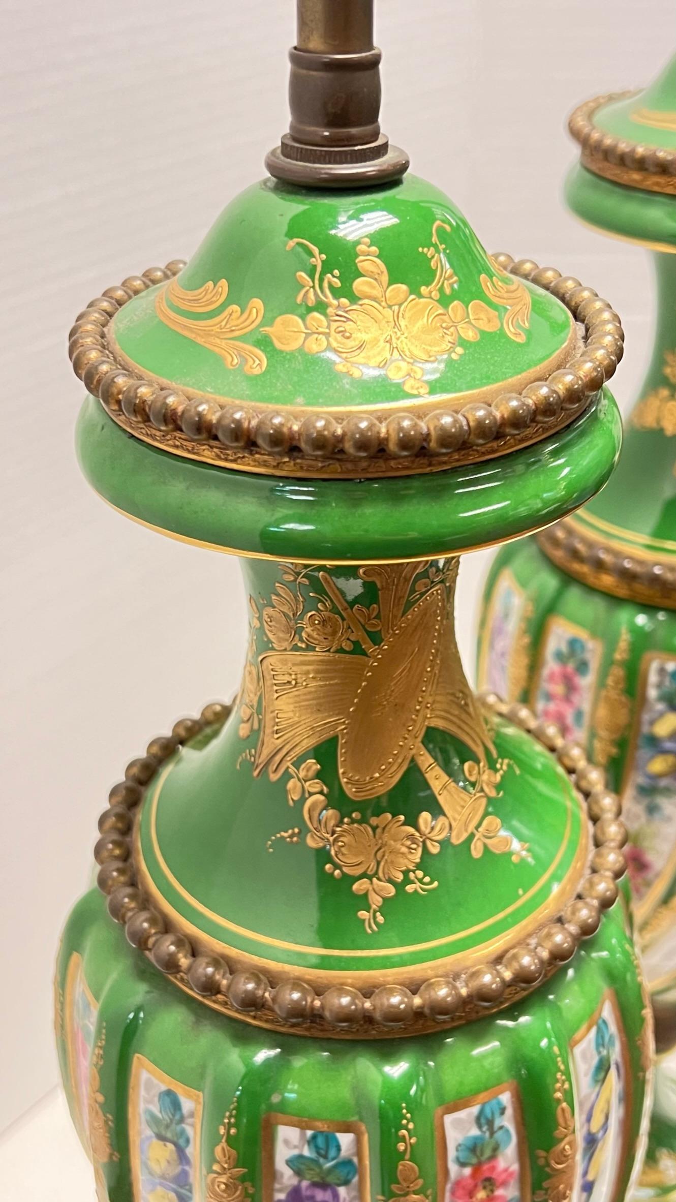 Pair of antique (19th century) French Sevres style porcelain vases with spirling ribbed shape, mounted as table lamps with bronze mounts and fine floral painted designs and gilding on green glazed ground.  In the Louis XVI / Napoleon III period