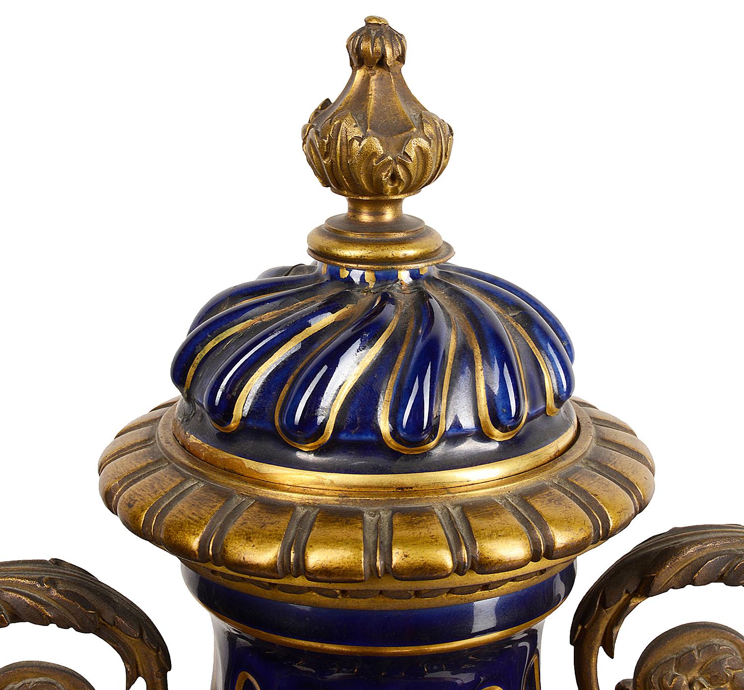 A very good quality pair of 19th century French Sèvres style porcelain lidded vases. Each with a cobalt blue ground with fluted twisted decoration with gilt lines, wonderful gilded scrolling foliate ormolu mounts.