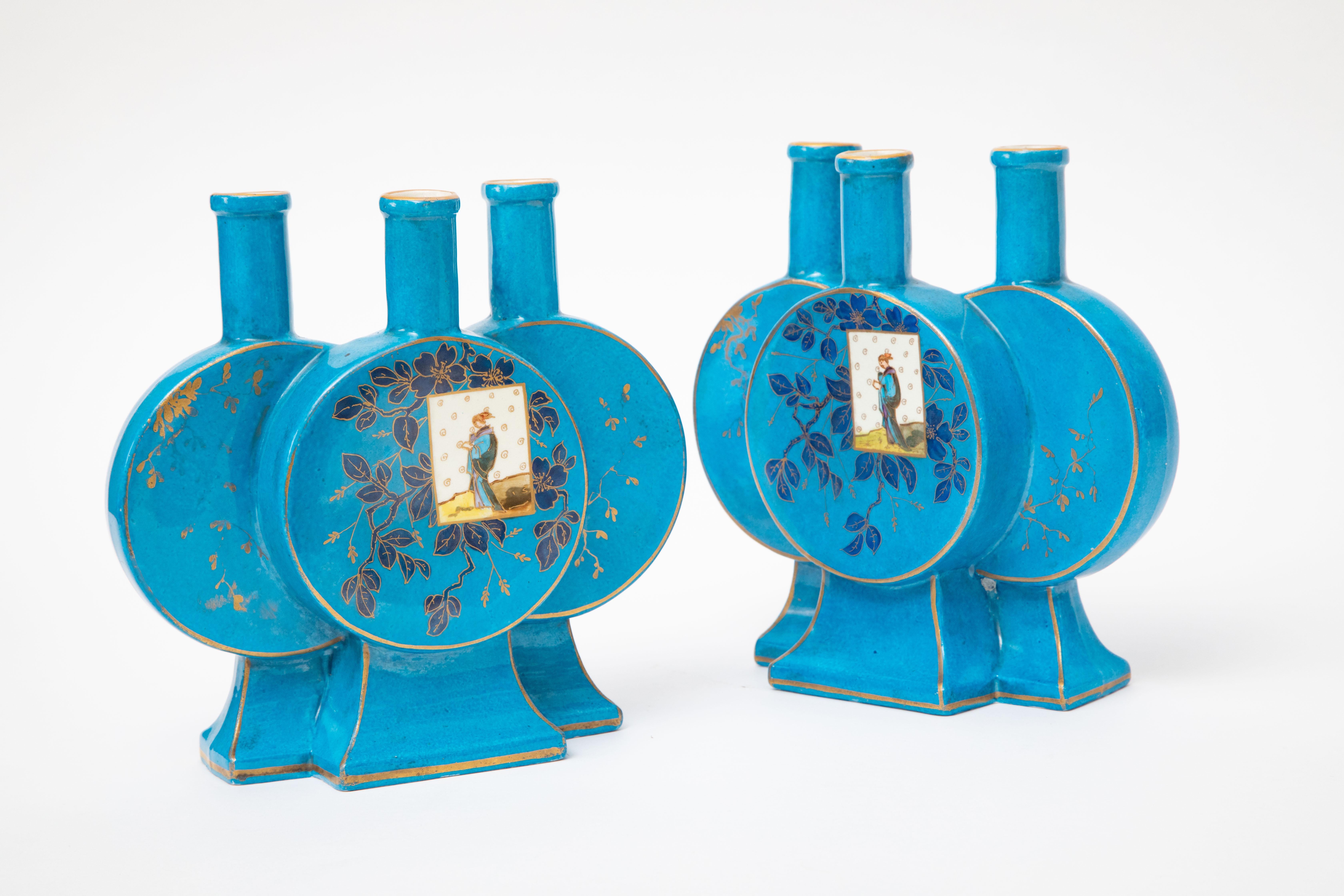 An antique pair of turquoise enamel vases with 3 compartments and panels of interesting chinoiserie figures inset cartouches on the front middle vase section. The unique triple flower holder design and the vibrant decoration makes for a great
