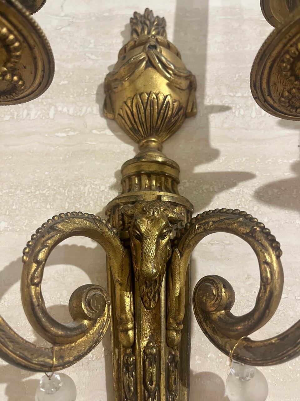 Coppia di sconsigliere neoclassiche in bronzo dorato del XIX secolo con teste di ariete e corna ritorte, foglie d'acanto e piano scanalato. Stile Luigi XVI