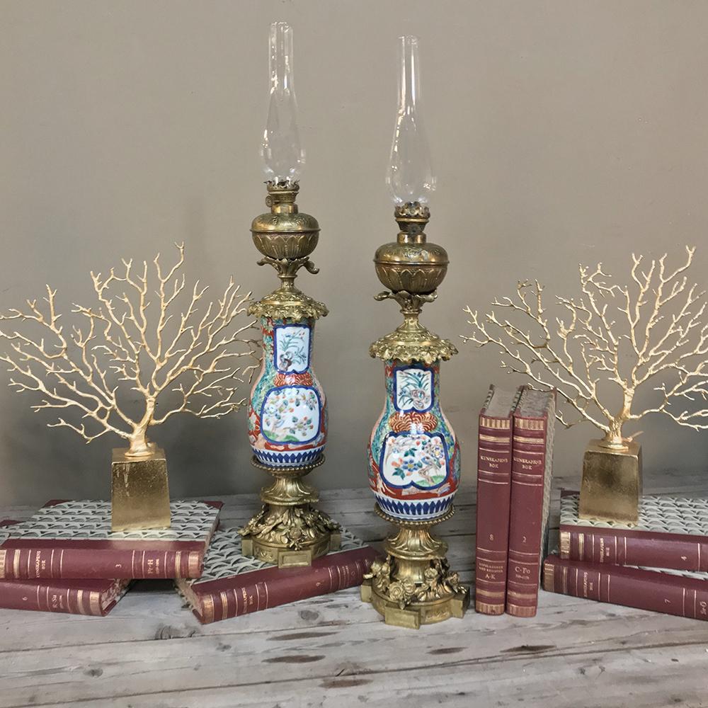 Pair of 19th century hand painted porcelain and bronze oil lanterns are exquisite works of art executed in amazing detail and vibrant color by hand, then glazed to preserve the beauty for centuries! Mounted on bronze bases and fitted with bronze
