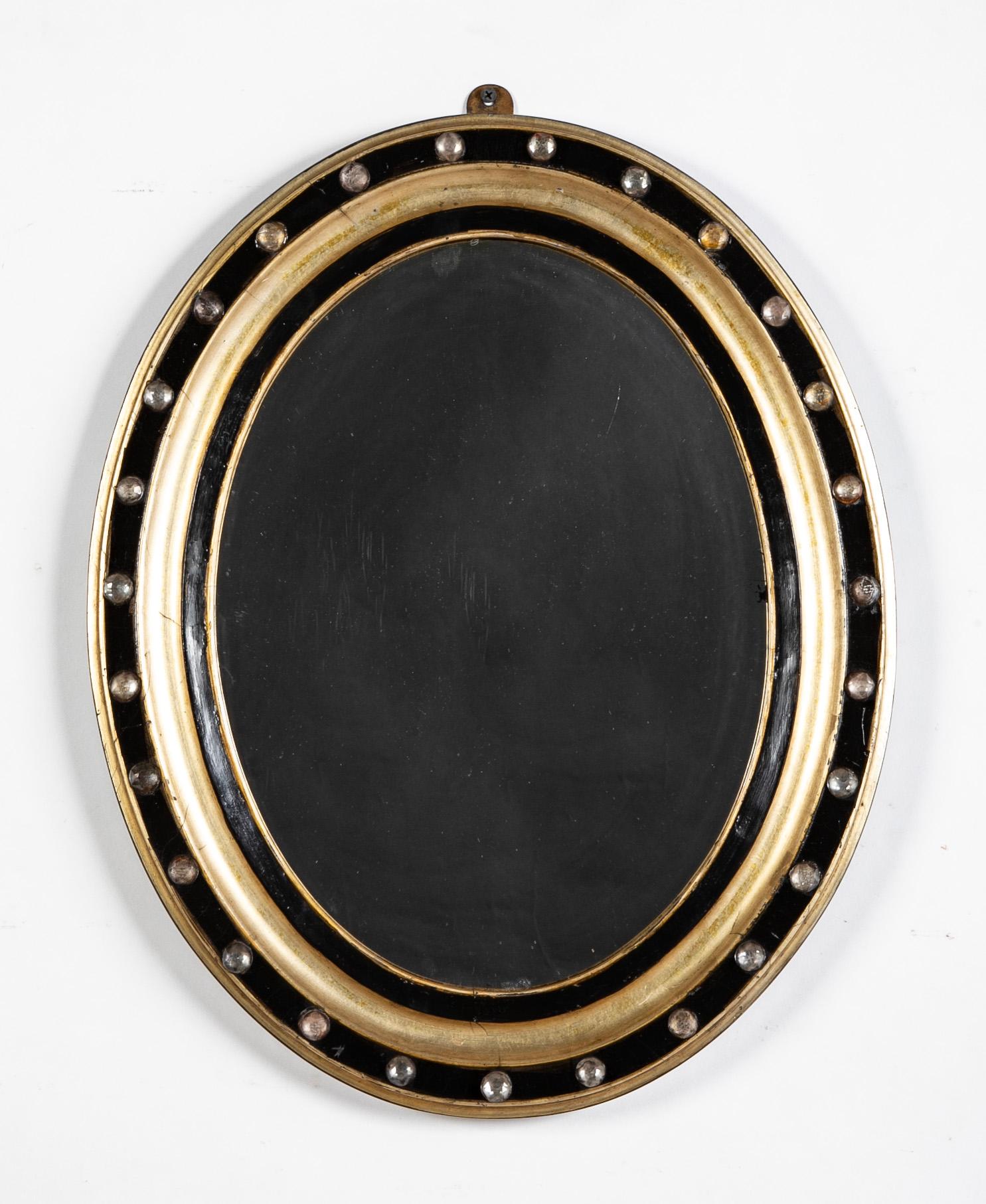 A handsome pair or parcel-gilt  and ebonized oval mirrors, The molded frame with bands of faceted and cabochon glass beads. Irish, Circa 1860. 

20 1/2 inches high by 16 3/8 wide by 1 3/4 deep

Provenance: Ex: Phillip Colleck Ltd. , old label on