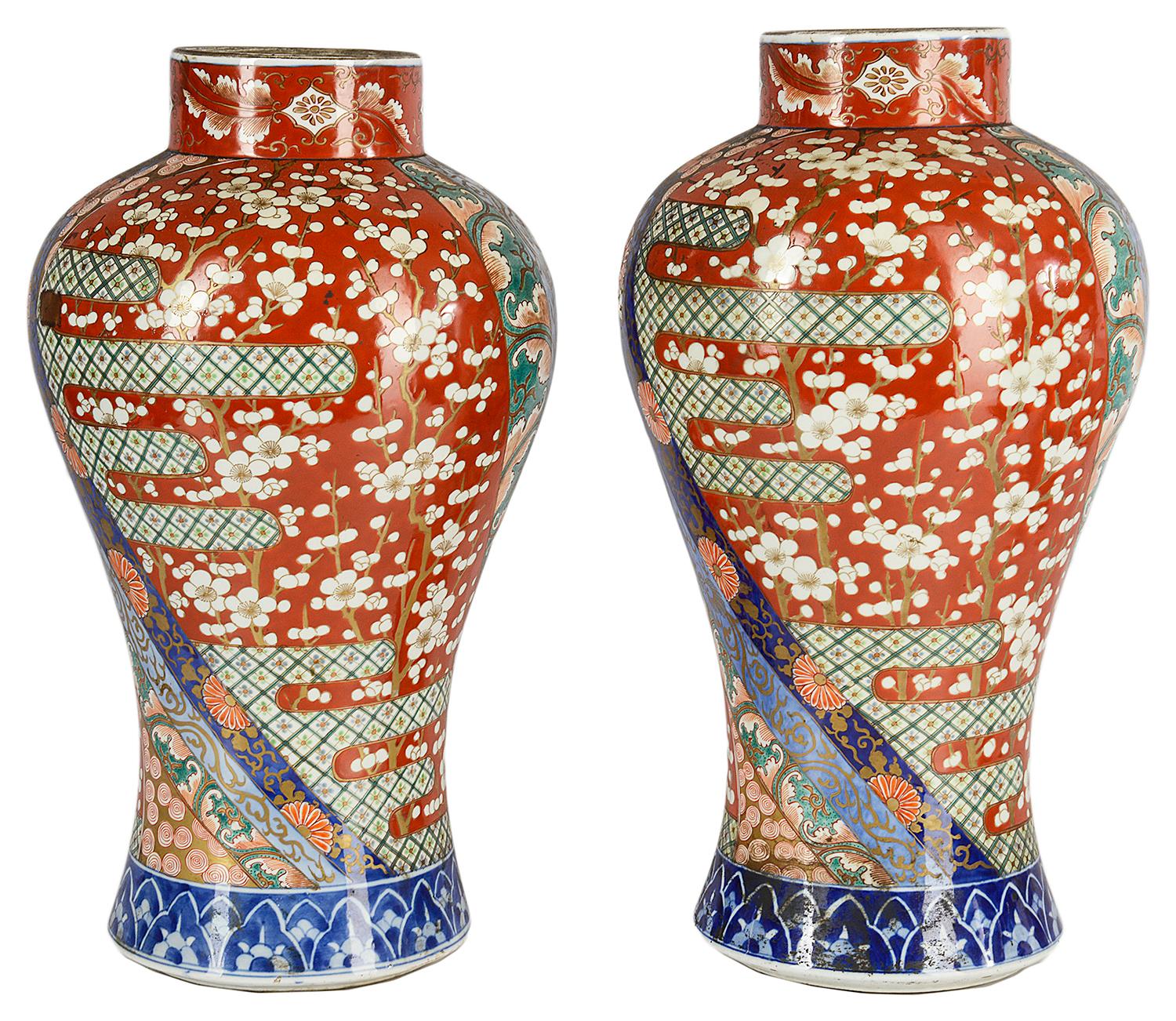 A very good quality and sticking pair of late 19th century Japanese Imari vases (Meiji period). Each having swirling panels around with classical flowers, motifs and decoration. Prunus blossom trees in the large panels and blue and white borders to