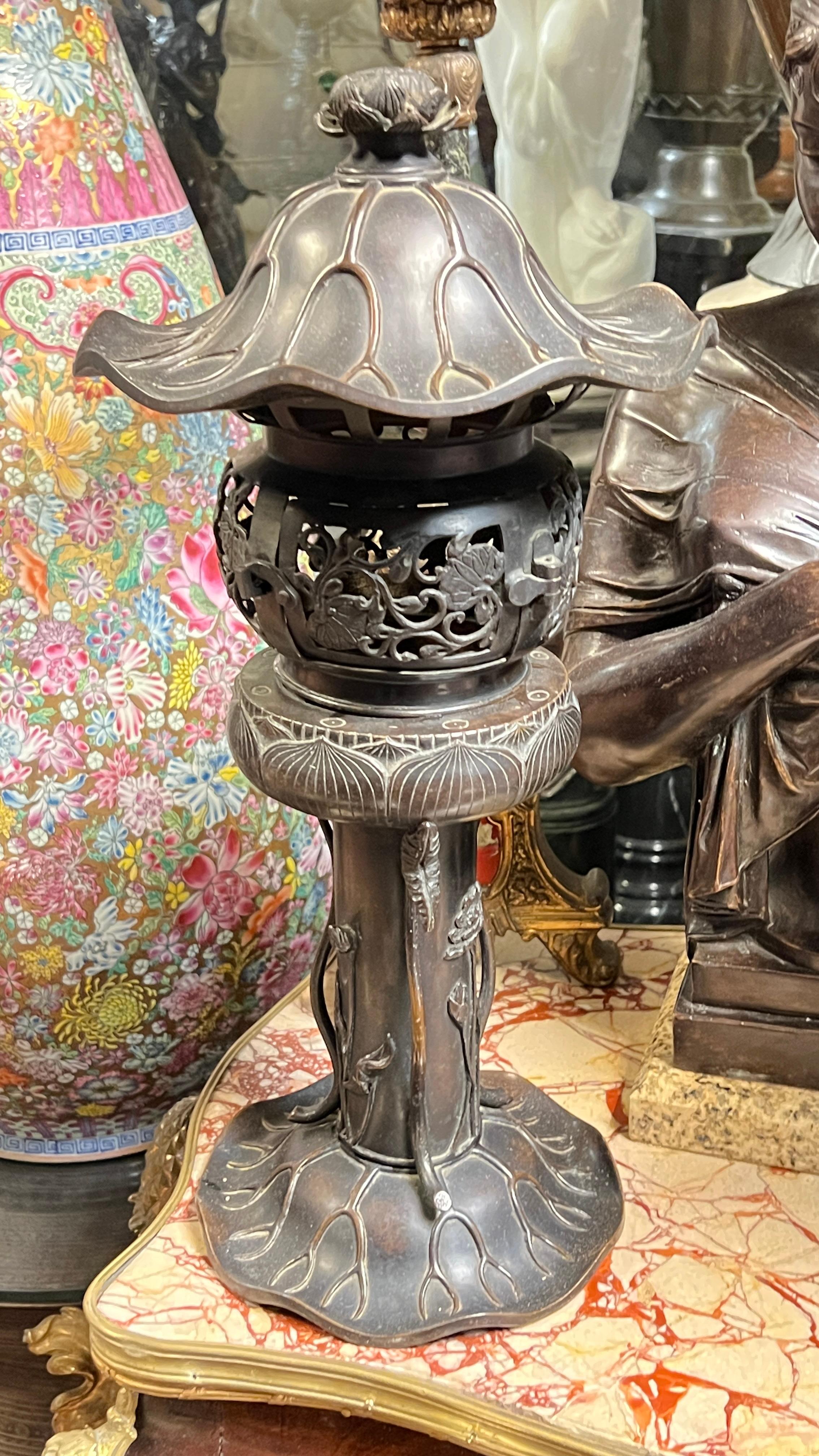 Pair of antique (late 19th century) Meiji period Japanese patinated bronze table lamps or incense burners of lily flower form measuring 21 inches tall.  Unsigned.
