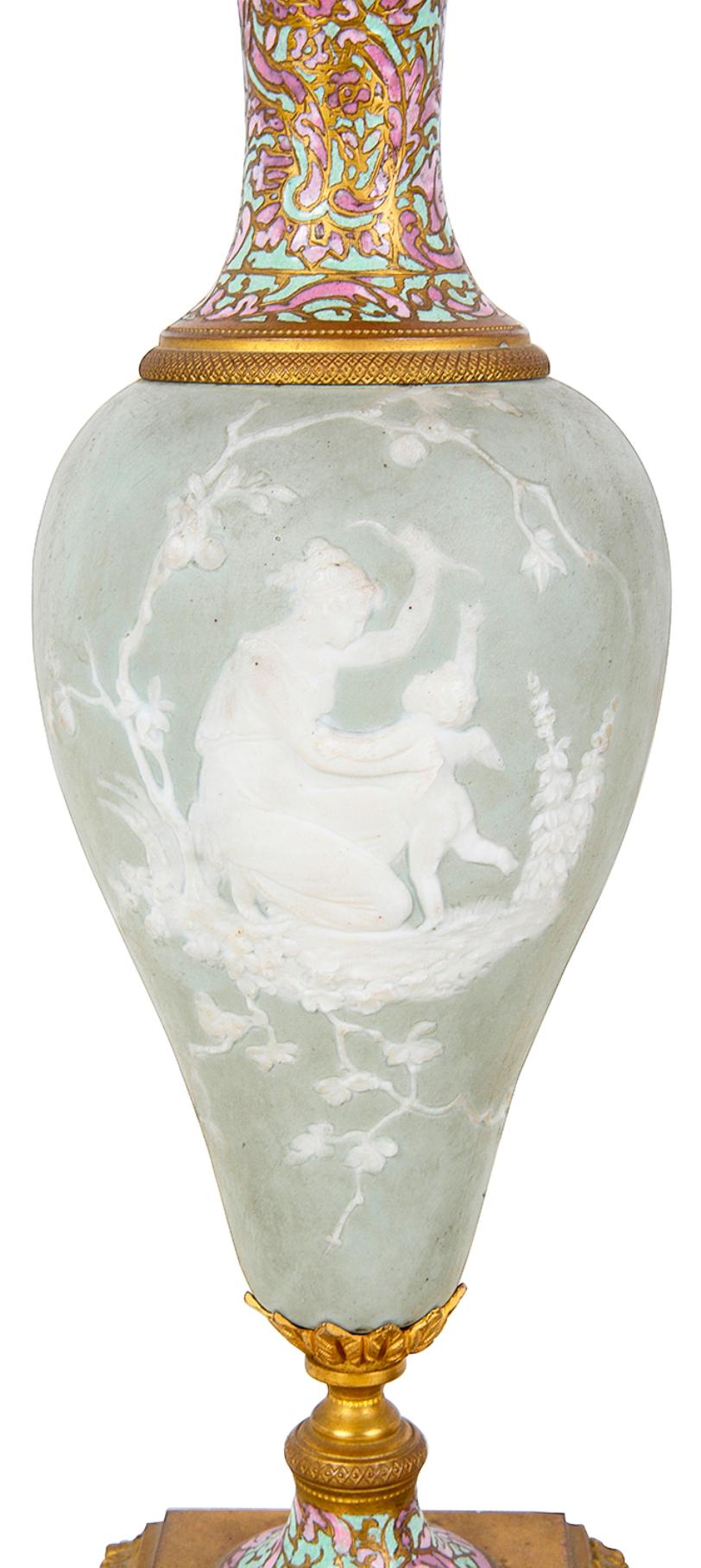 Paire de vases en porcelaine de style Wedgwood de bonne qualité, datant de la fin du XIXe siècle, représentant chacun des scènes classiques, montés sur des supports en bronze doré avec une décoration en émail champlevé multicolore.
 